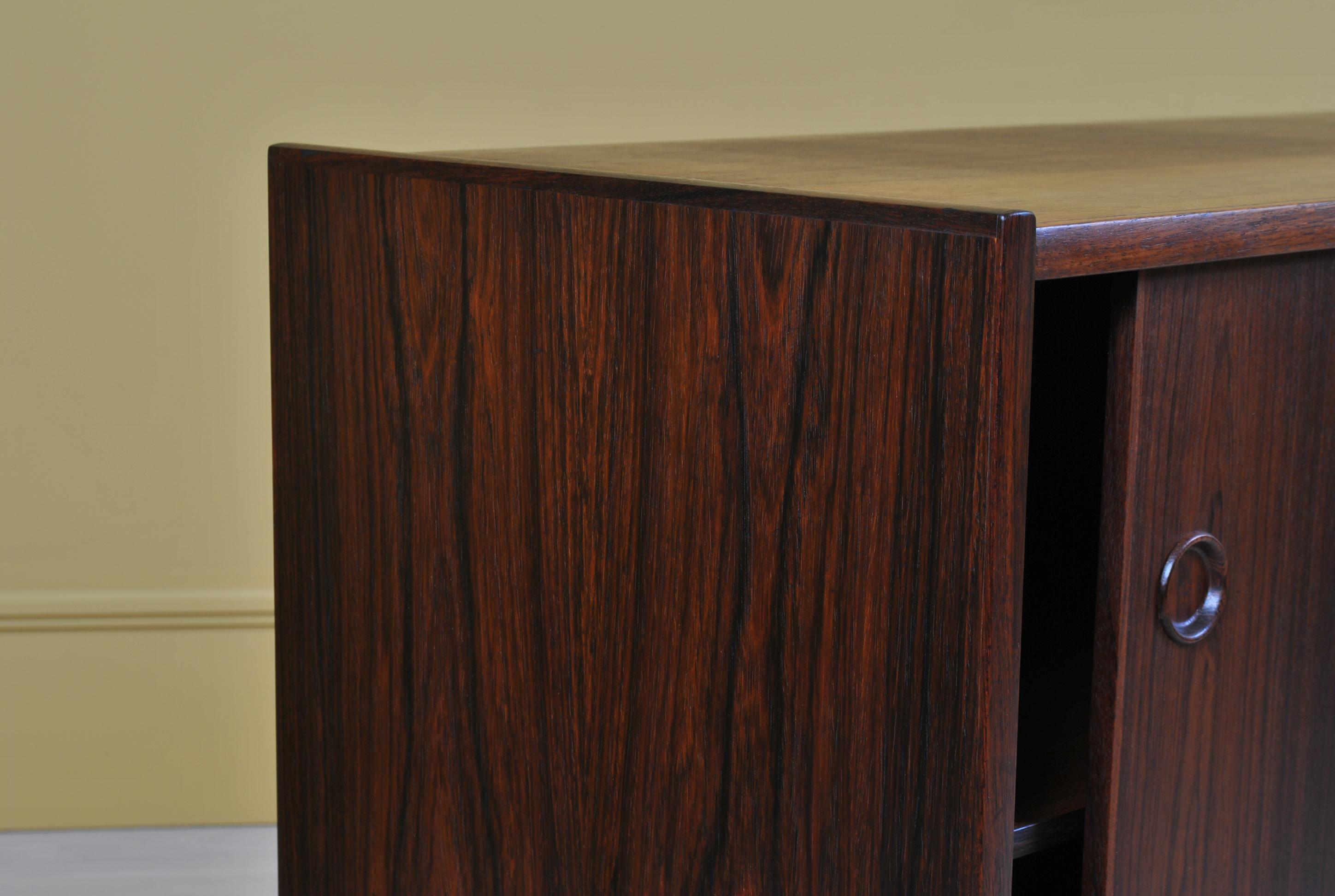 A Danish midcentury rosewood credenza or sideboard. Double sliding doors with internal shelf and 2 small maple drawers.