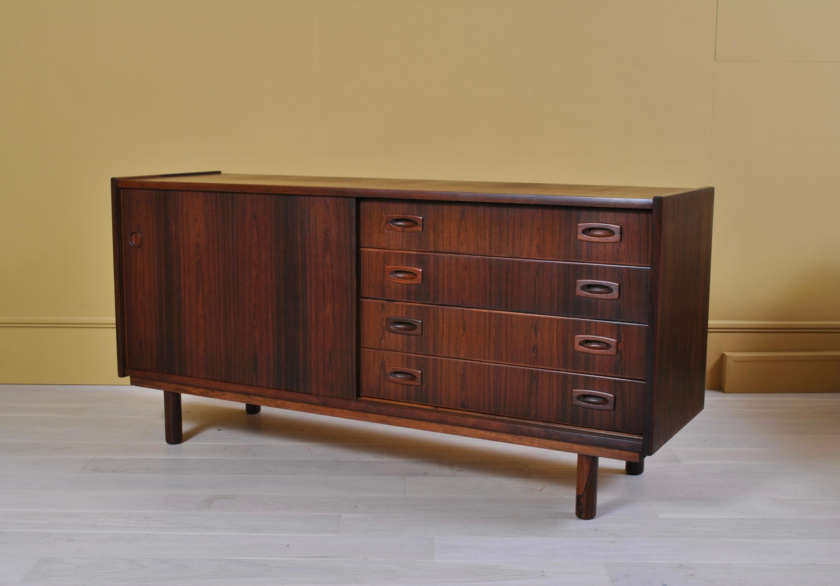 A Danish midcentury credenza or sideboard by Dammand Rasmussen. One sliding door with internal shelf and 4 maple construction drawers.
    