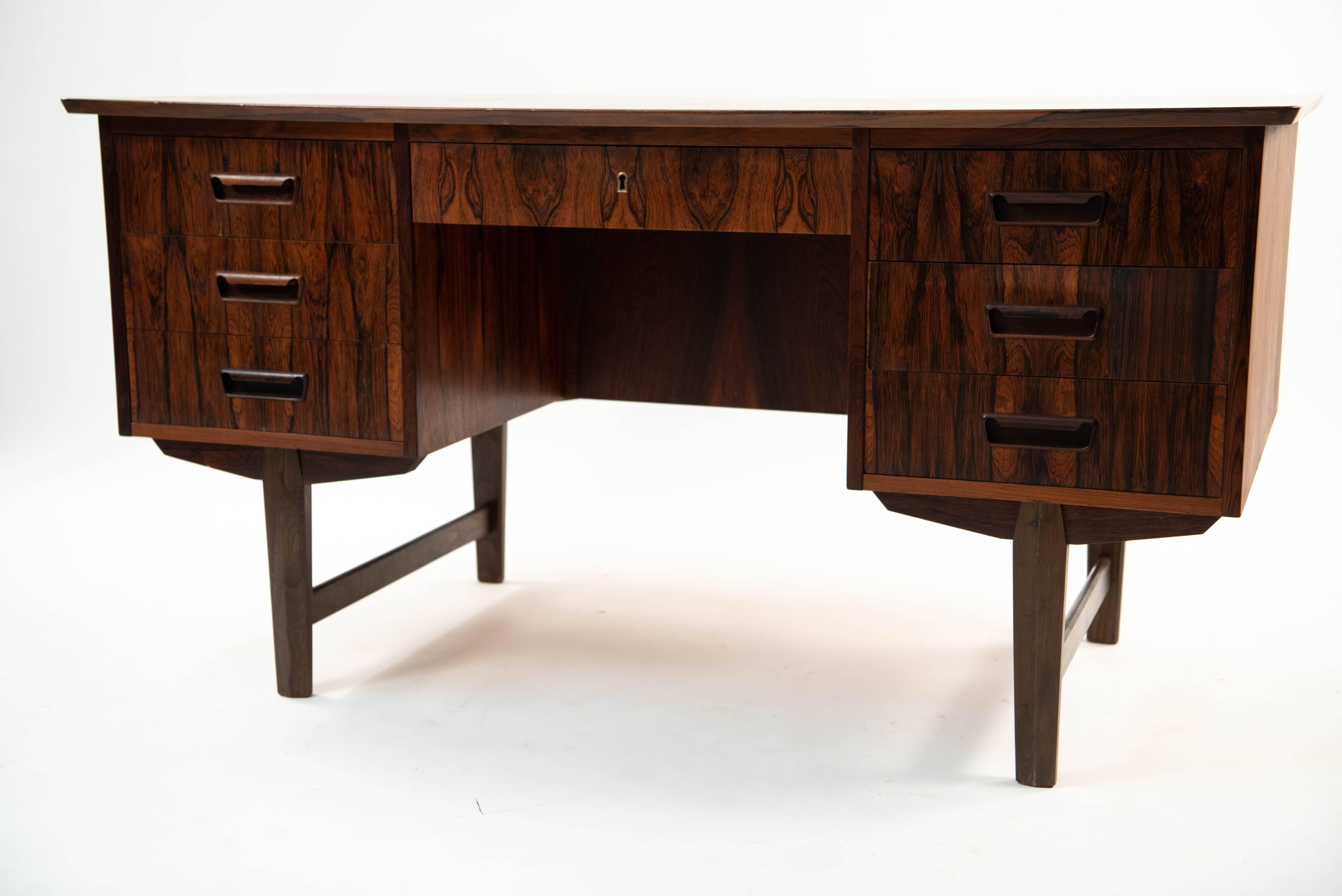 This Danish midcentury desk is made of rosewood with a stunning color and grain. It sits on sturdy legs and features drawers on either side to maximize available storage.