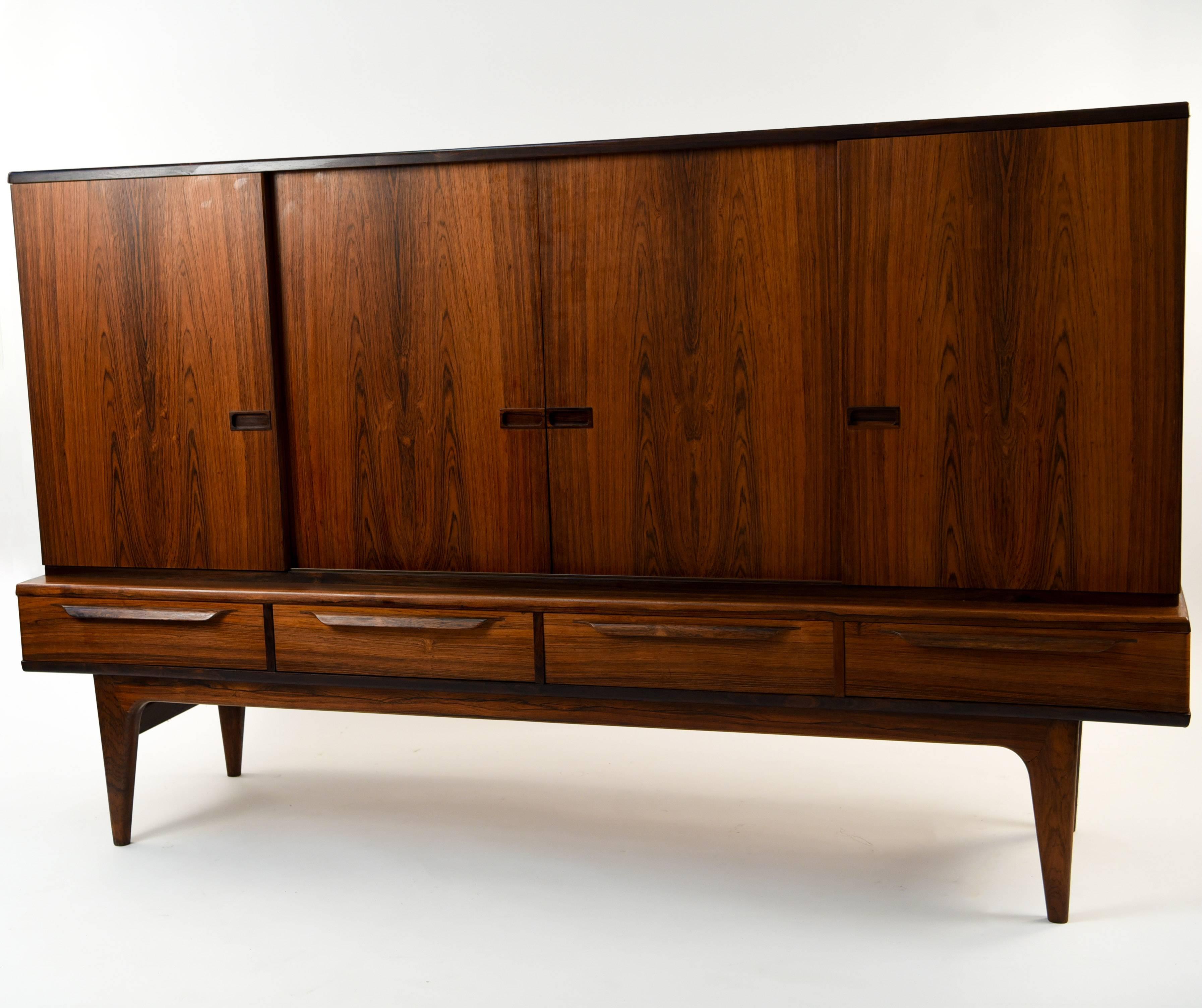 This Danish midcentury tall sideboard is a wonderful sturdy storage piece that combines style with functionality. The rosewood is of a beautiful color and grain. This piece will have a great presence in any room.