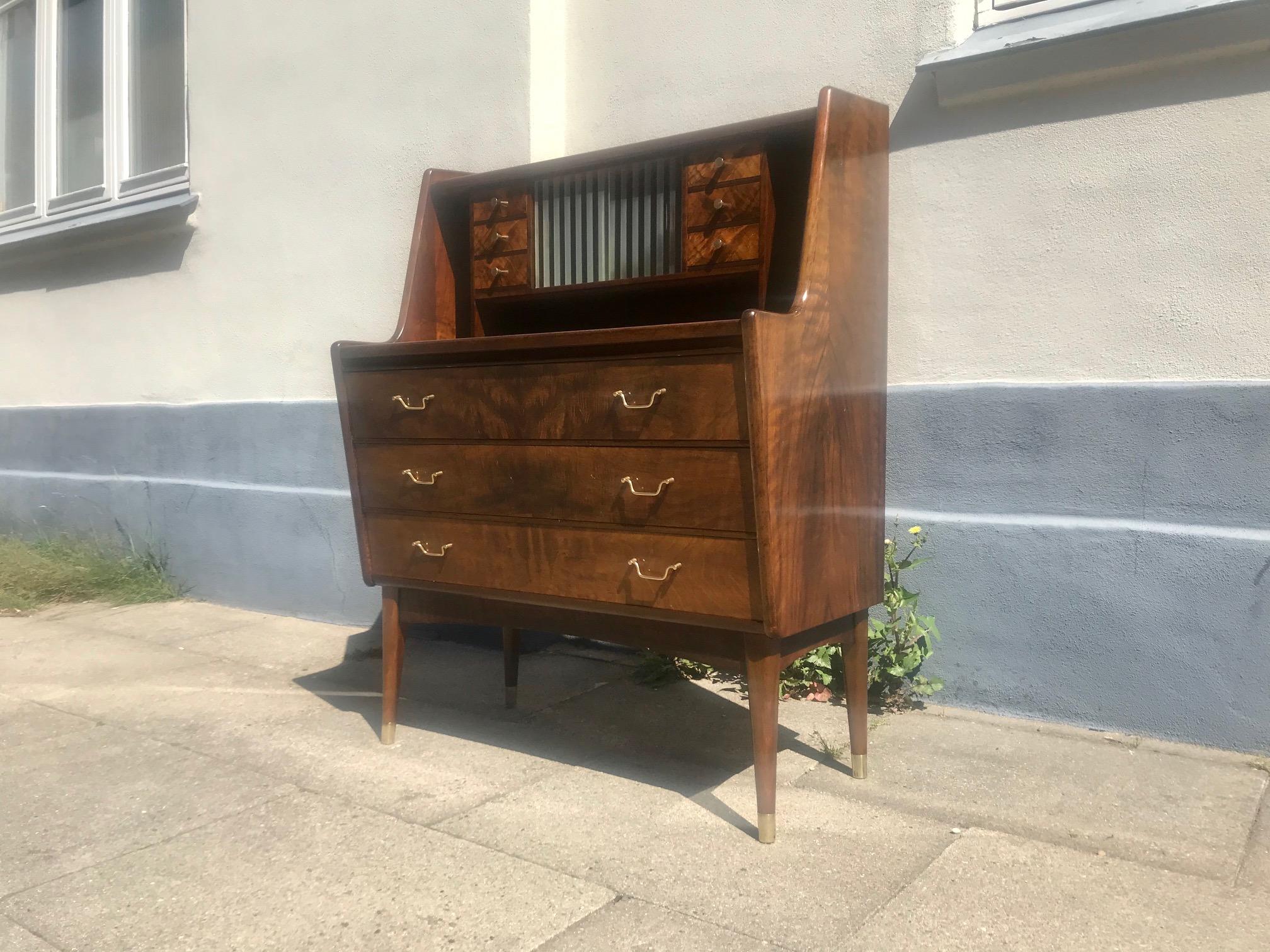 A Danish secretaire from circa 1950. Every visible surface has shows walnut veneer and the wood grains are 'mirror'/matched by the woodworker wherever this was possible. It has three packed main drawers below and a top with six small drawers and a