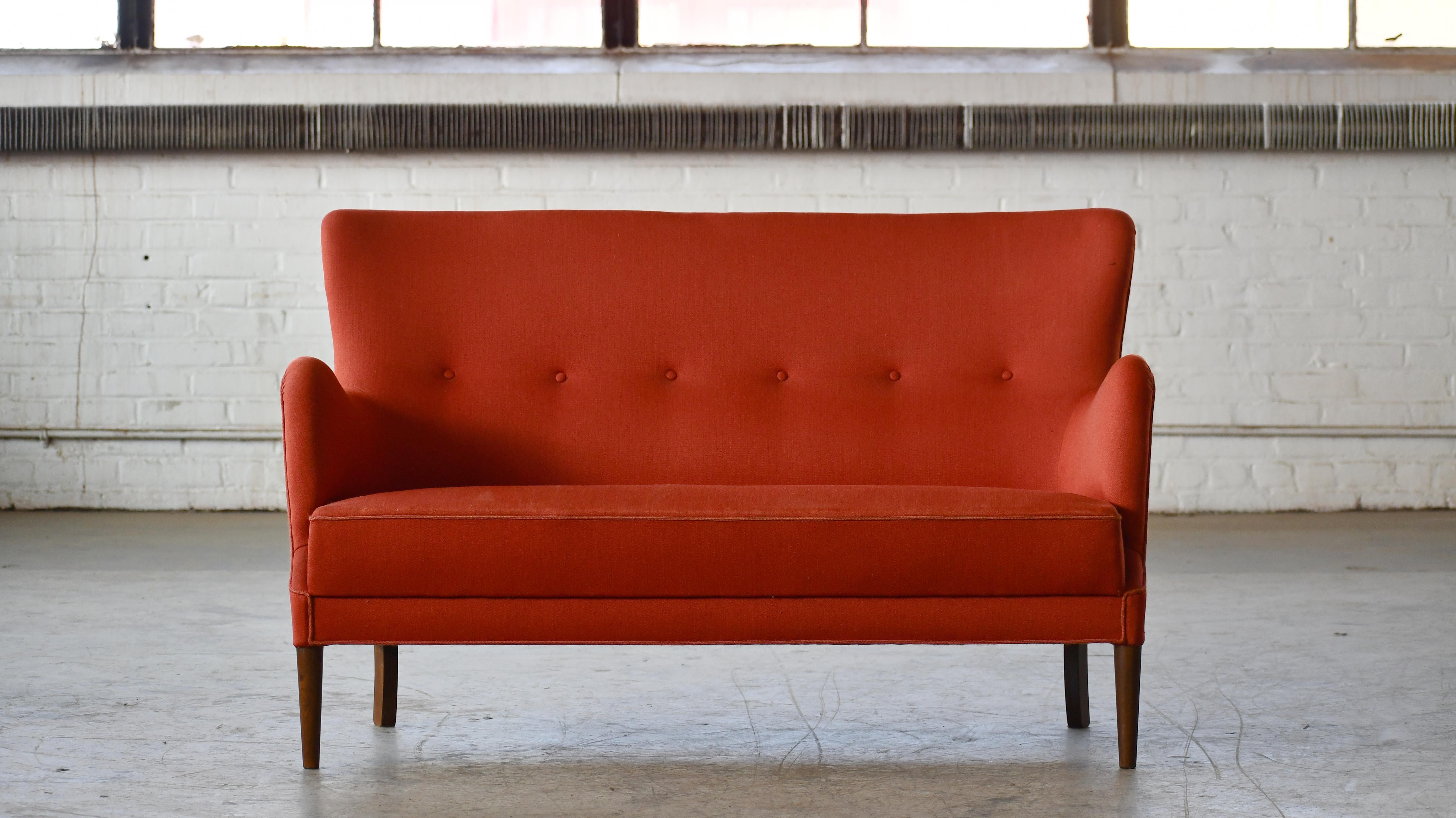 Linee classiche e molto eleganti per questo divanetto di Peter Hvidt per Fritz Hansen. Realizzato nel 1955 circa. Lo schienale e la seduta sono belli e solidi, mentre il telaio e le gambe in faggio rimangono robusti. Il divano è stato rivestito di