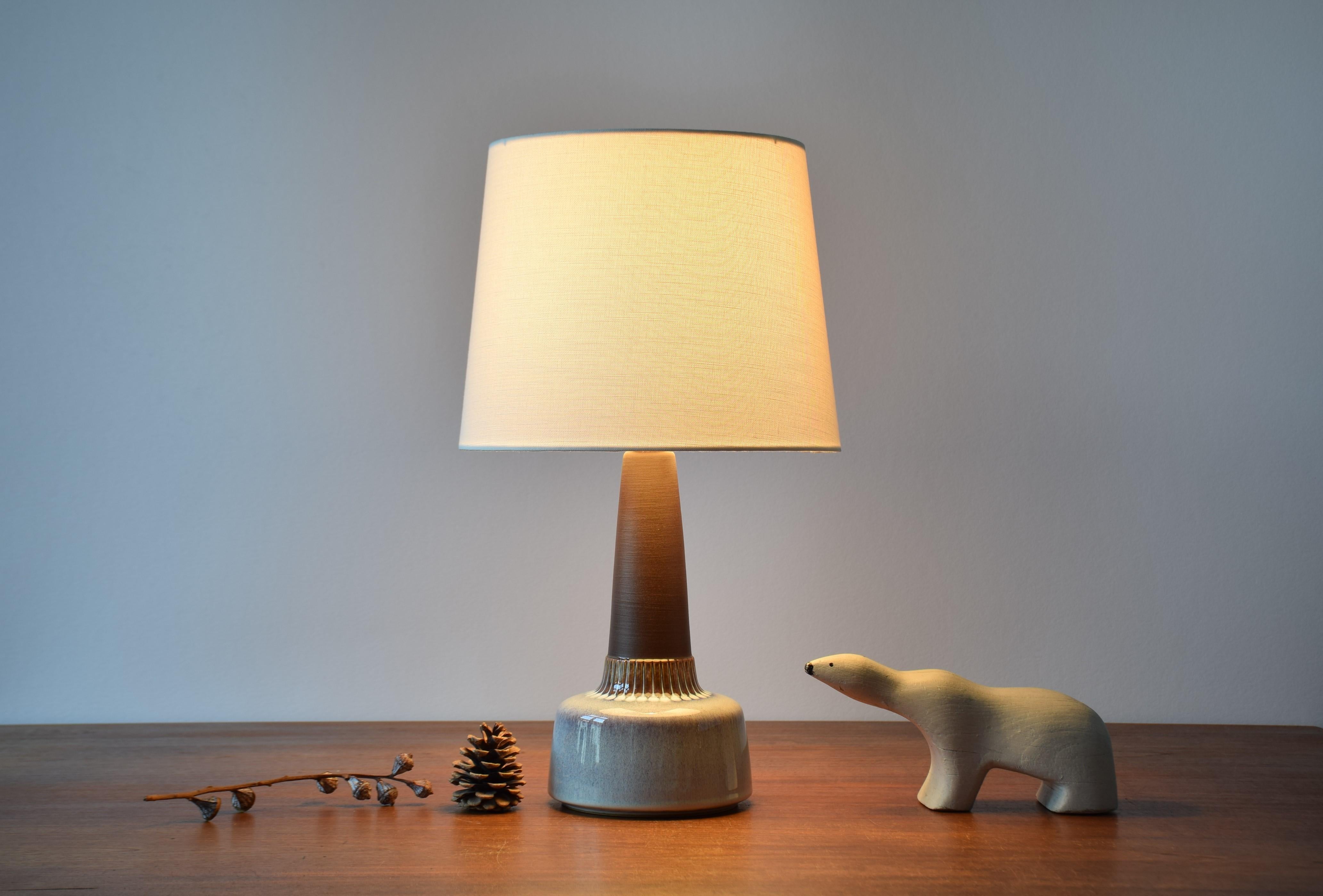 Midcentury Danish table lamp by Danish ceramist Einar Johansen for Søholm. Made circa 1960s.

The lampbase has a matte brown neck contrasted by a shiny glaze in mother-of-pearl colors and circular dots around the lower part.

The lamp has an