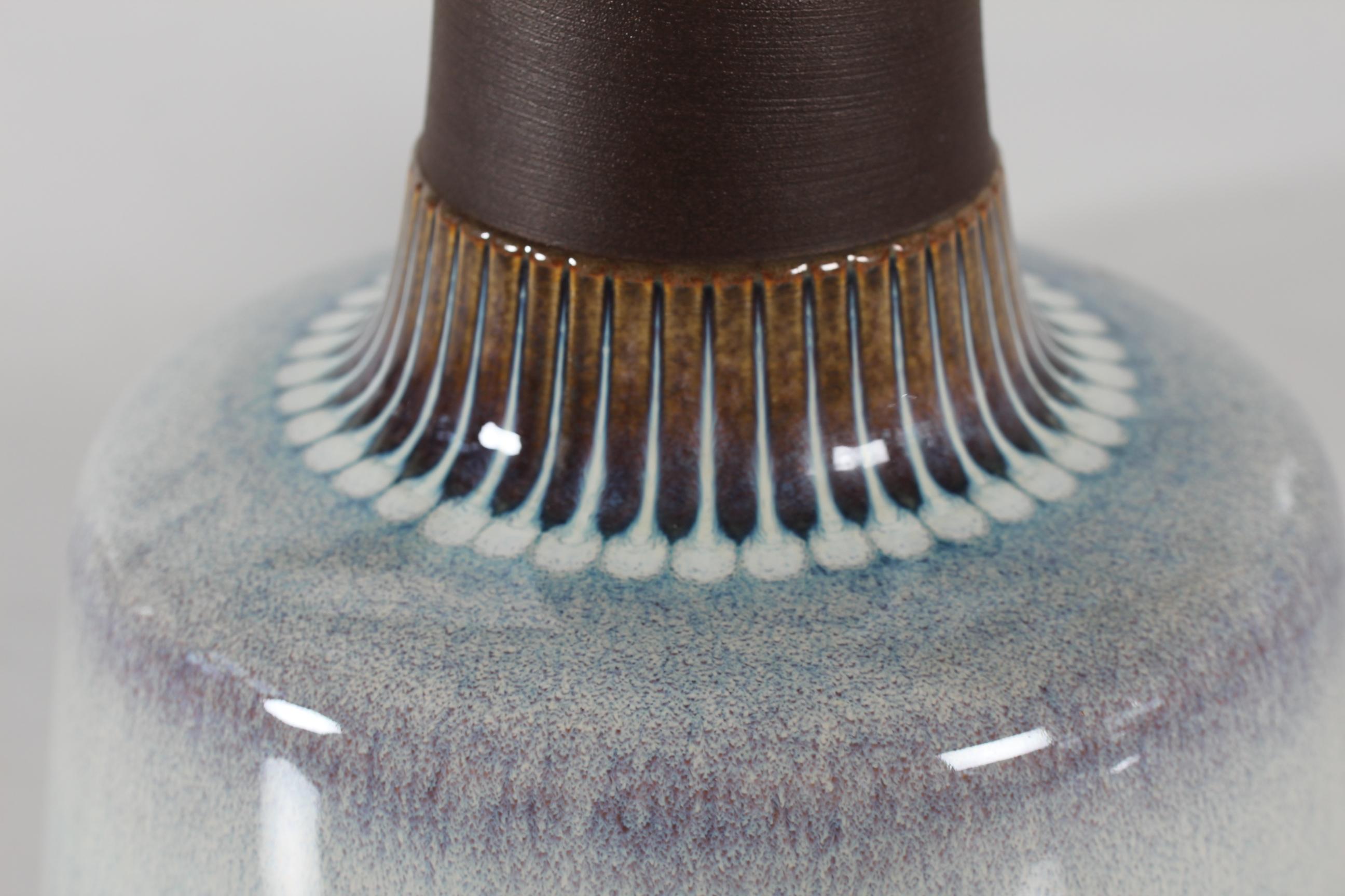 Lampe de table danoise du milieu du siècle dernier du céramiste danois Einar Johansen pour Sholm. Fabriqué vers les années 1960.

La base de la lampe présente un col brun mat contrasté par une glaçure brillante dans des couleurs de nacre et des