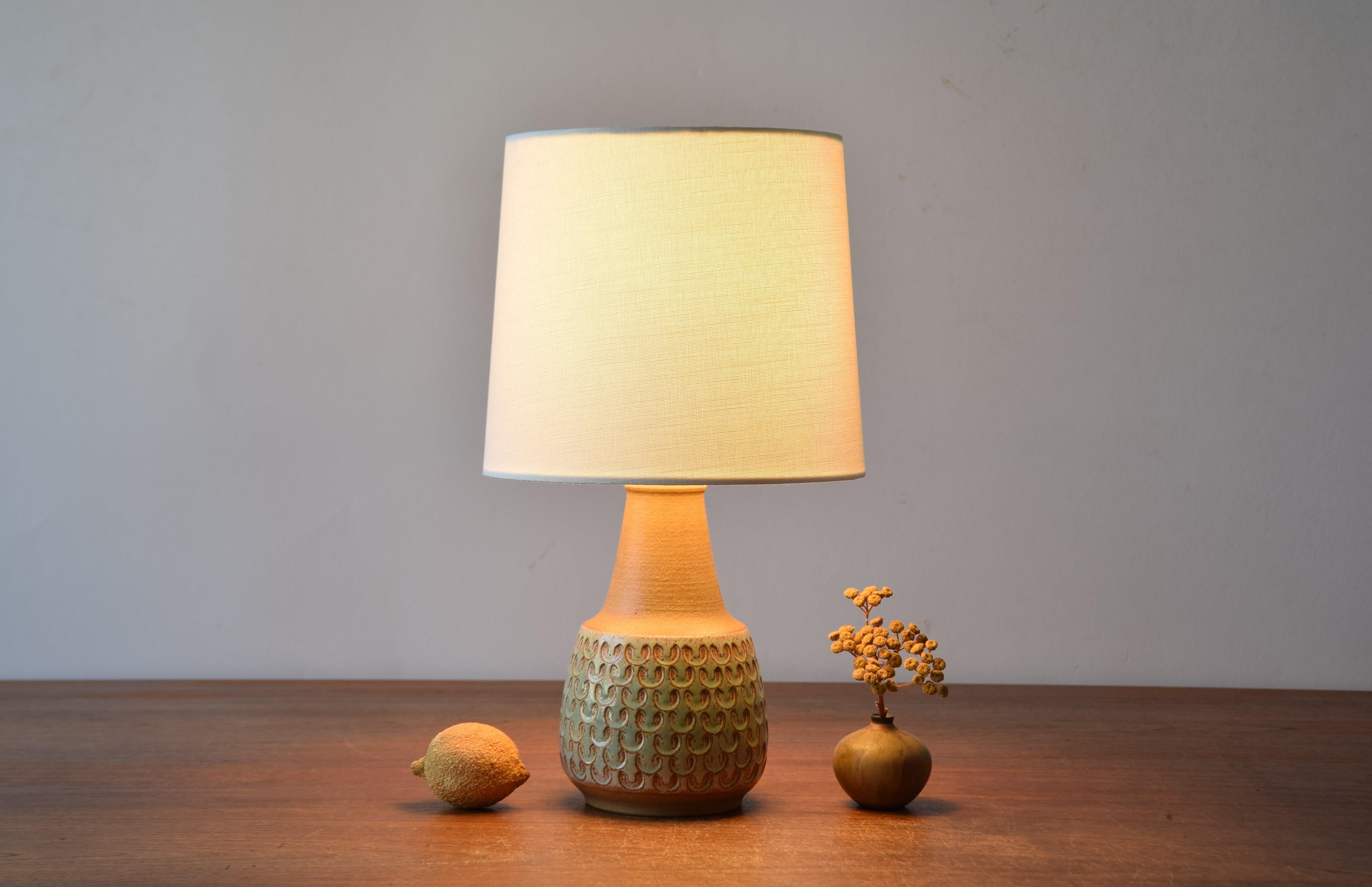 Midcentury Danish table lamp by Søholm Stentøj, Denmark. Made circa 1960s.
The lamp has repeated decor covered with a glossy pale green glaze contrasted by an unglazed neck in warm brown. 

Included is a new lamp shade designed and made in