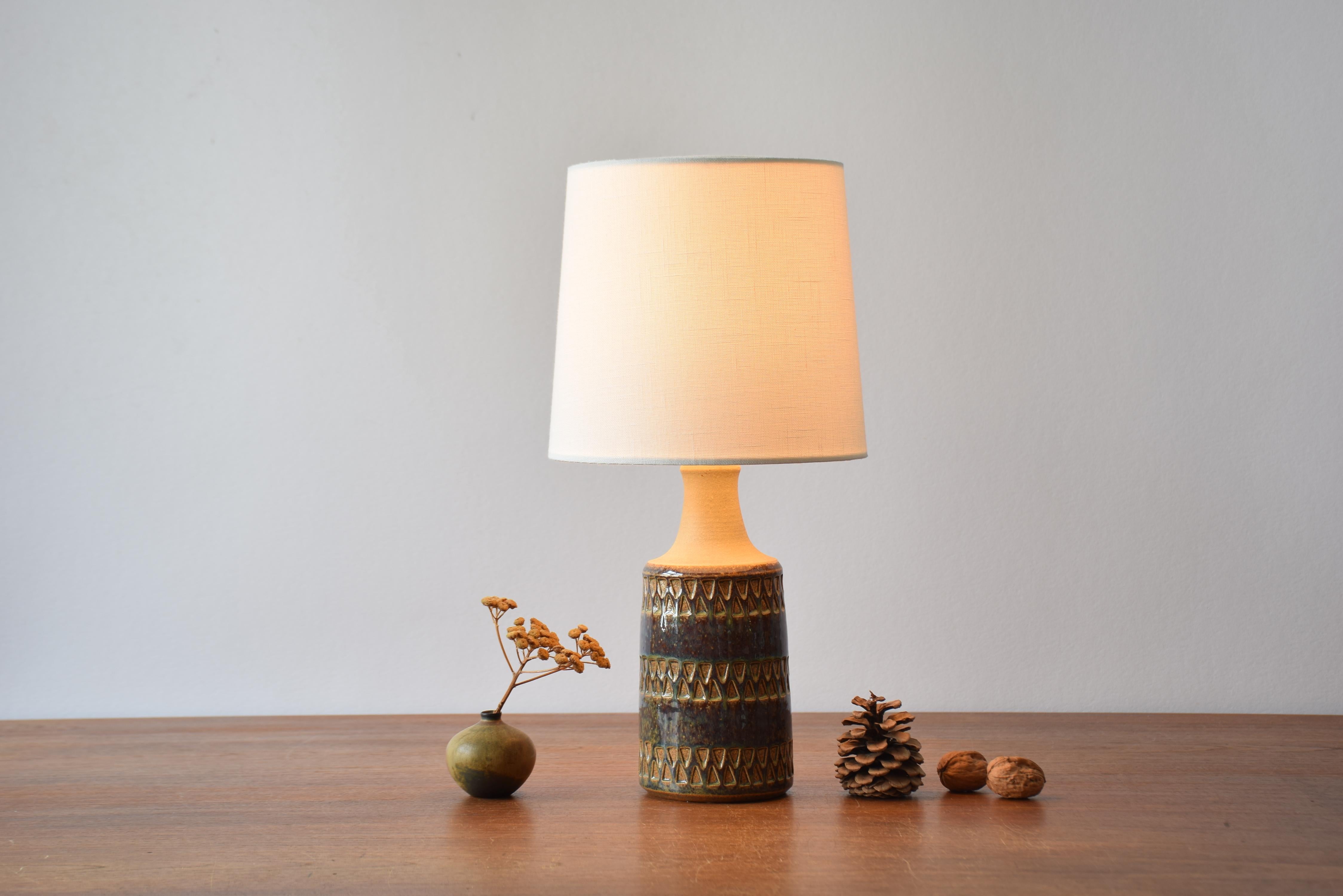 Small Midcentury Danish table lamp by Søholm Stentøj, Denmark. Made circa 1960s.
It is decorated with a mix of brown, blue and caramel colored glaze on a repeated triangle decor. 

Included is a new lamp shade designed and made in Denmark. It is