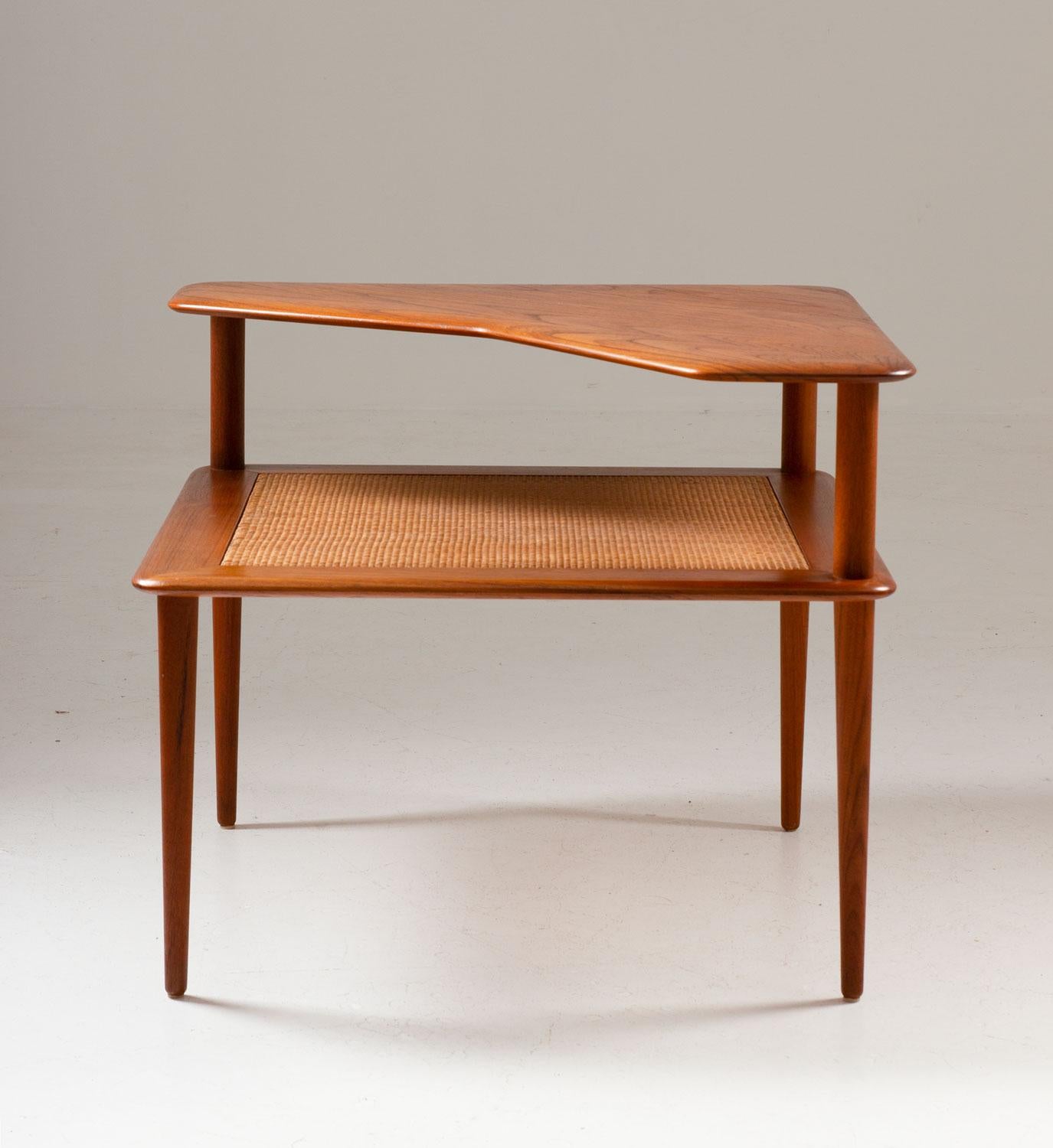 Beautiful side or corner table by Peter Hvidt & Orla Mølgaard-Nielsen for France & Son. 
The table consists of two table tops, the upper one is beautifully shaped and made of solid teak, the lower one is quadratic and made of rattan.
Condition: