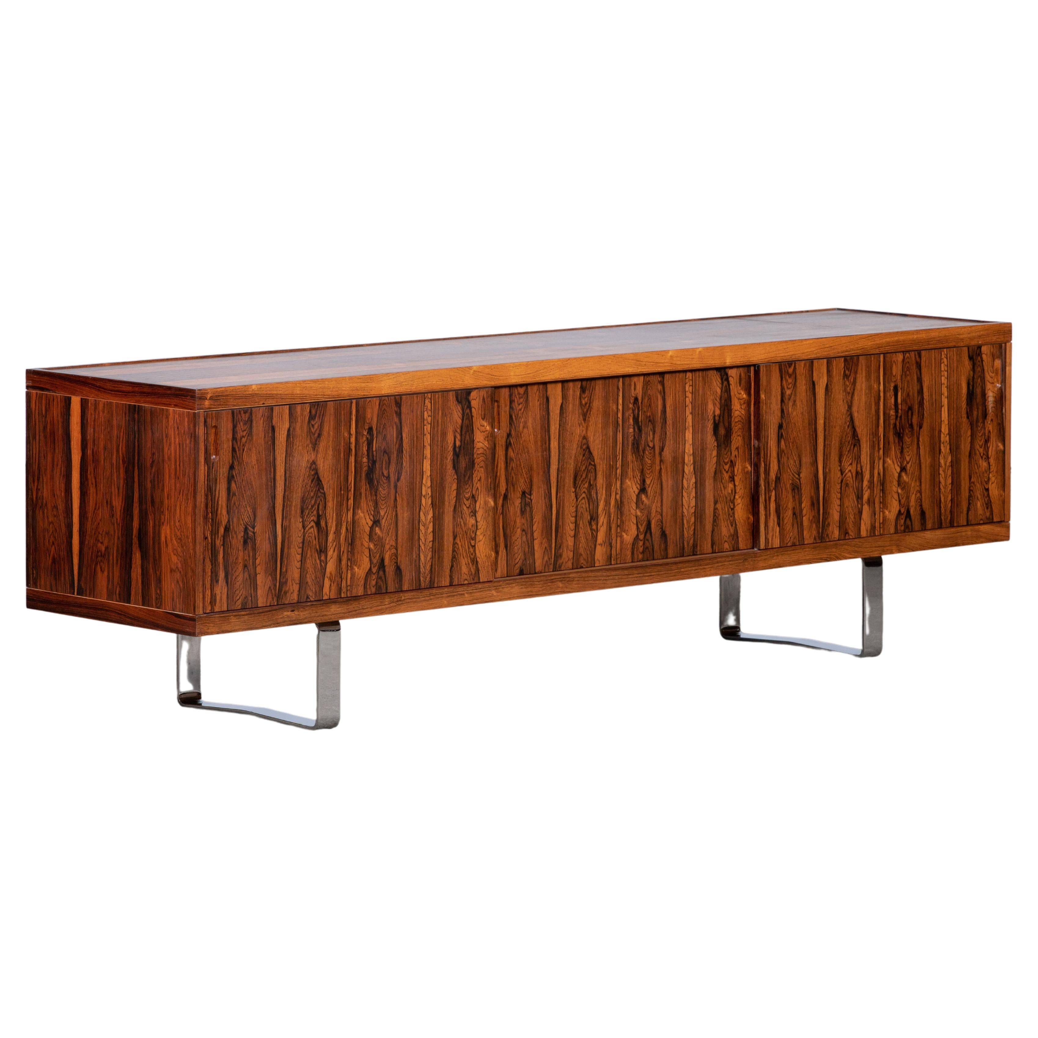A vintage Danish sideboard in rosewood that has the sophistication of rosewood with the sleek contemporary feel of minimal style and chrome legs. This piece would look at home in a mid-century period home or the most contemporary. The craftsmanship