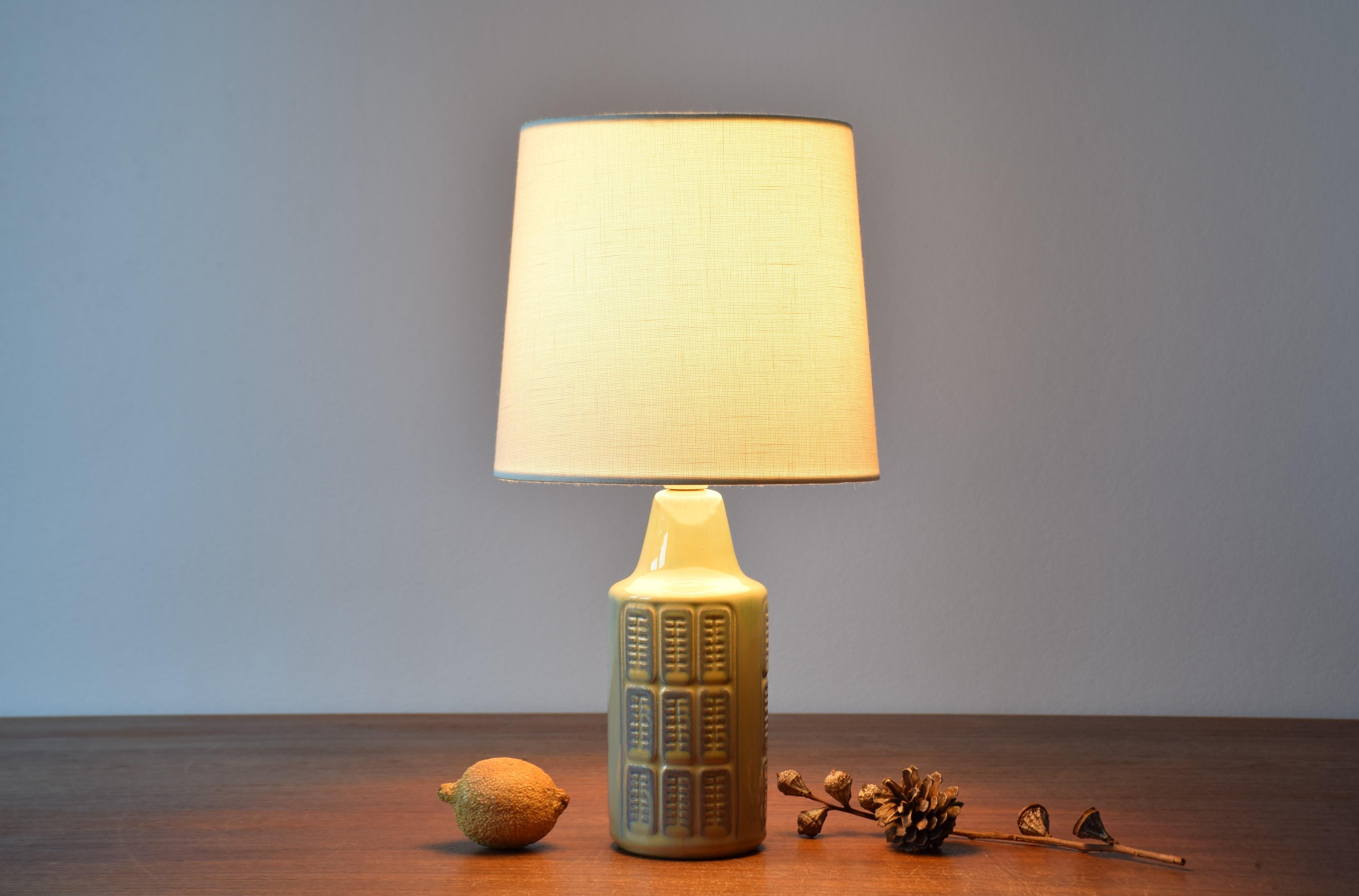 Small table lamp by Einar Johansen for Søholm Stentøj, Denmark, circa 1960s.
The lamp has a shiny pistachio green glaze with pale purple elements over an embossed repeated graphic decor. 

Included is a new clip on lamp shade designed and made in