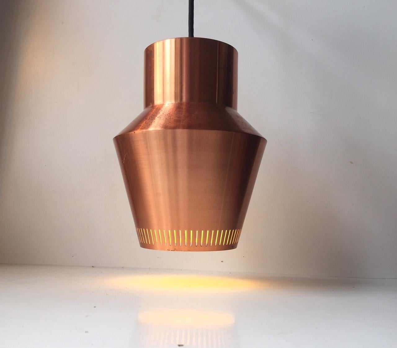 Solid copper pendant light with vertical perforations and a white reflective inner shade. The copper has developed a patina over the span of time. It provides a warm light. Its by Fog & Mørup Denmark and the style is reminiscent of Alvar Aalto and