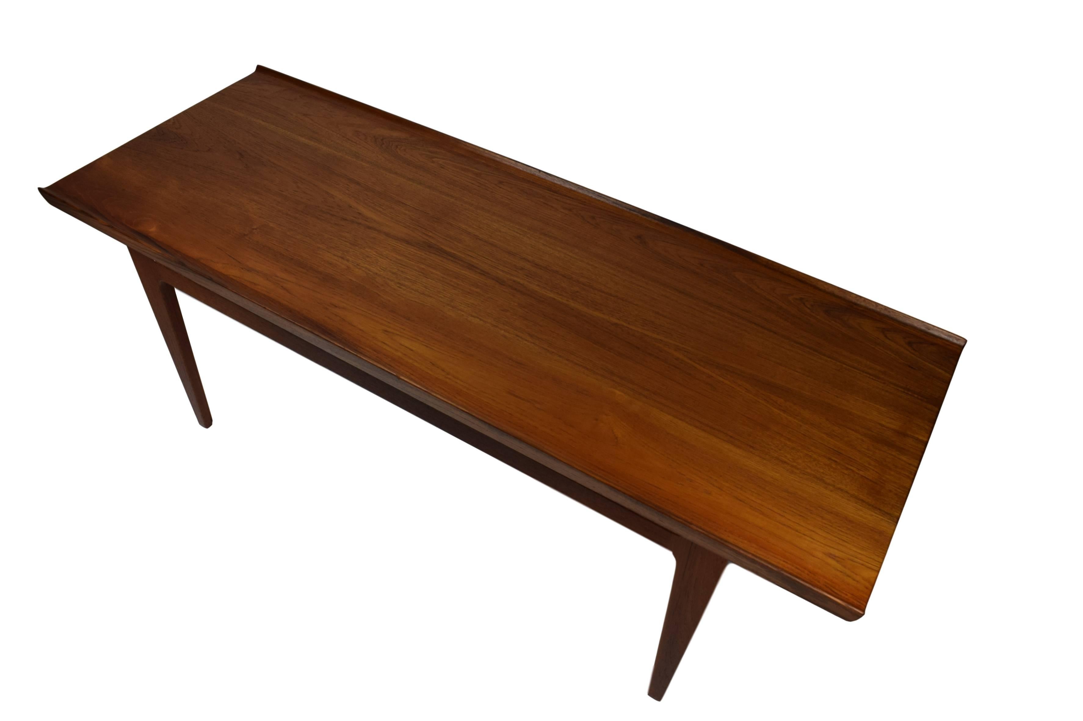 An original Danish midcentury solid teak coffee table by Finn Juhl (1912-1984). Model FD631 designed in 1958. Produced by France & Daverkosen (after 1957 called France & Son). The table has raised edges along both sides and is newly refinished.