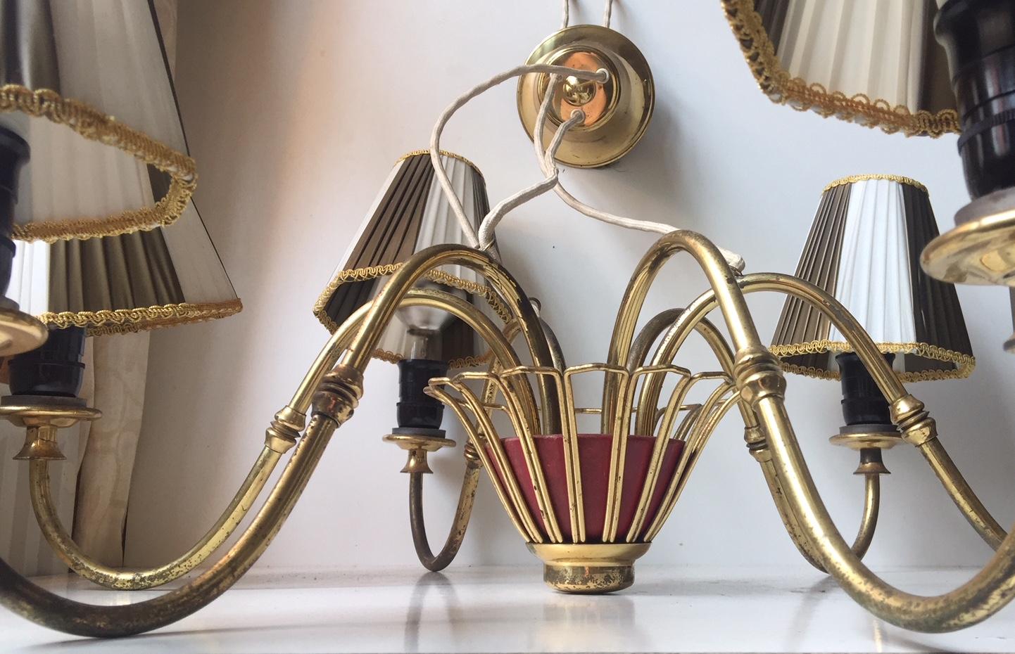 Large 6-armed brass chandelier designed and manufactured by Lyfa in Denmark during the 1950s. It features its original brass canopy and period shading. The style of this light is reminiscent to Josef Frank and Paavo Tynell.
