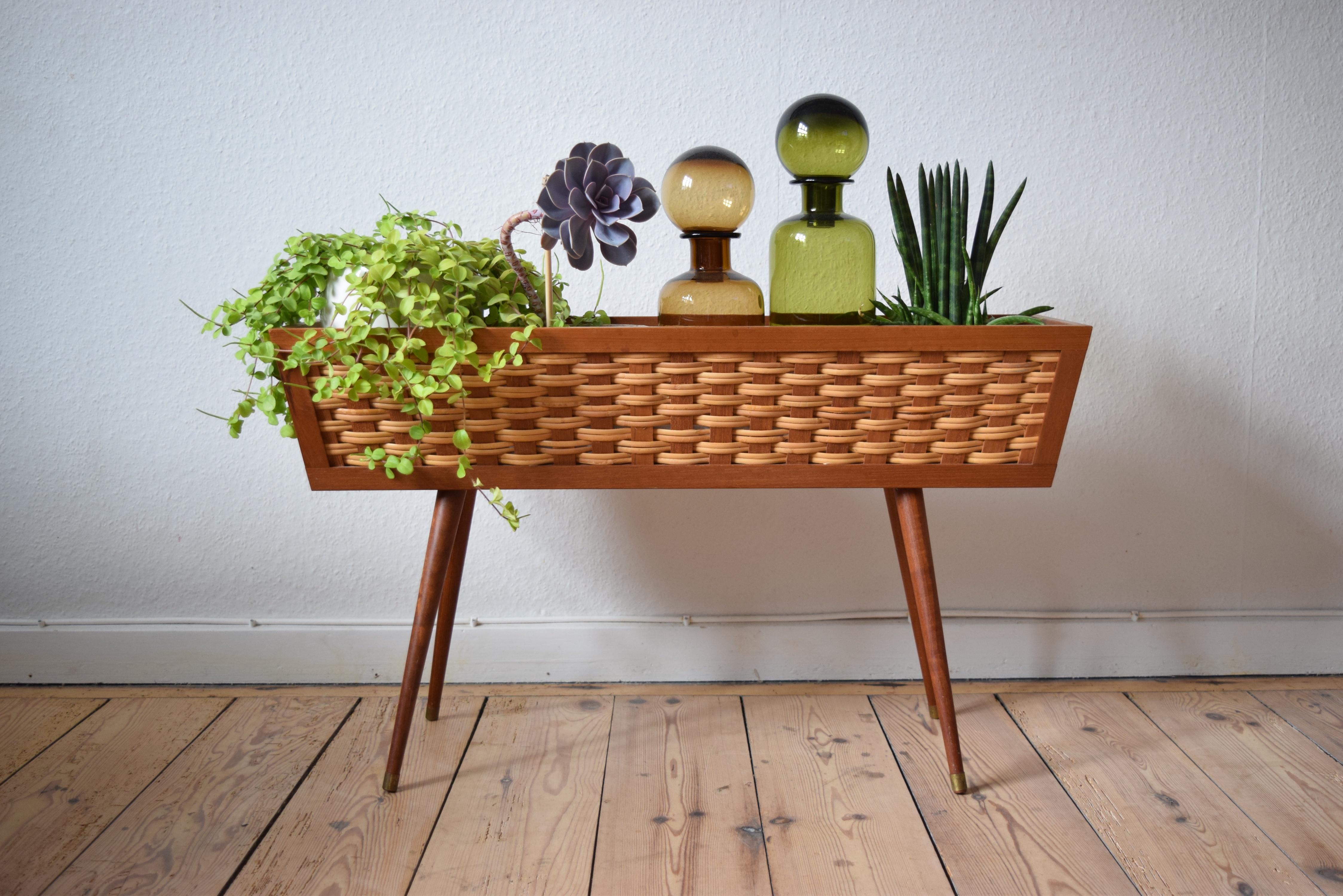 Vintage teak and cane planter manufactured in Denmark in the 1960s. Sits on delicate turned and tapered teak legs with brass 'shoes'. Polystyrene insert. Legs can be removed for easier shipping. Very few marks on this piece.
