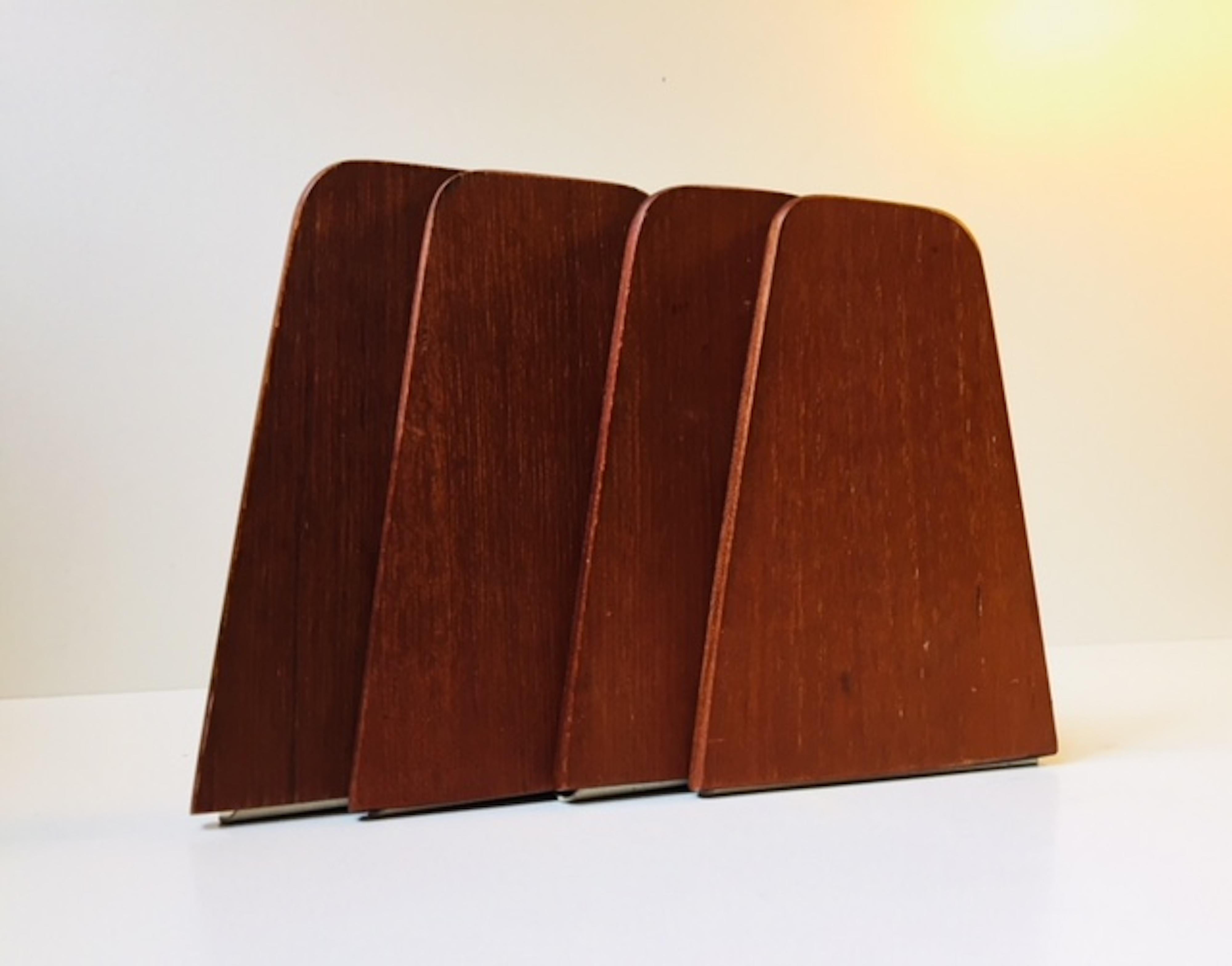 A set of four bookends in teak with steel rests. Designed by Kai Kristiansen and manufactured by FM Møbler in Denmark during the 1960s.