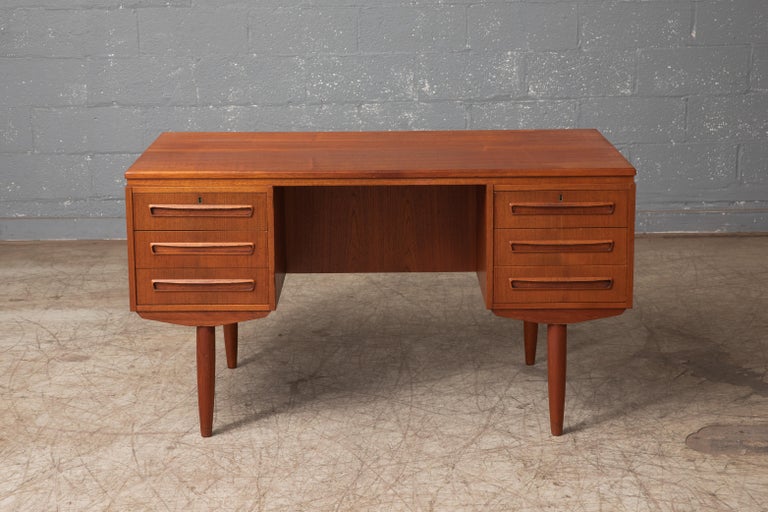Beautiful Danish small executive desk in the style of ai Kristiansen and made in Denmark sometime in the late 1950's. This desk is slightly smaller than a traditional executive desk and fits well in urban dwellings. Finished on all sides and with a
