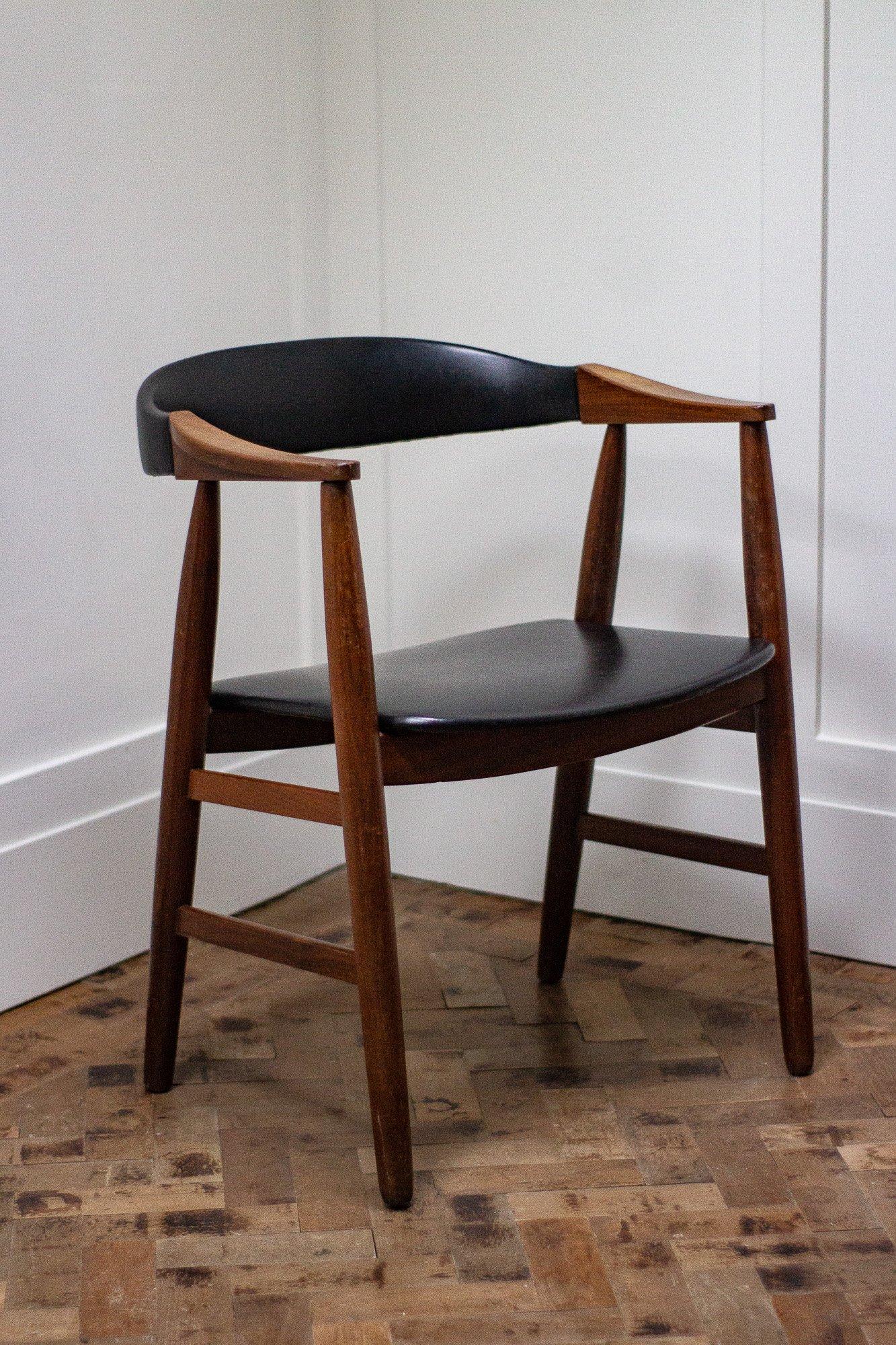 Midcentury chair made of teak with a black vinyl seat pad backrest.

Designer and maker unknown.