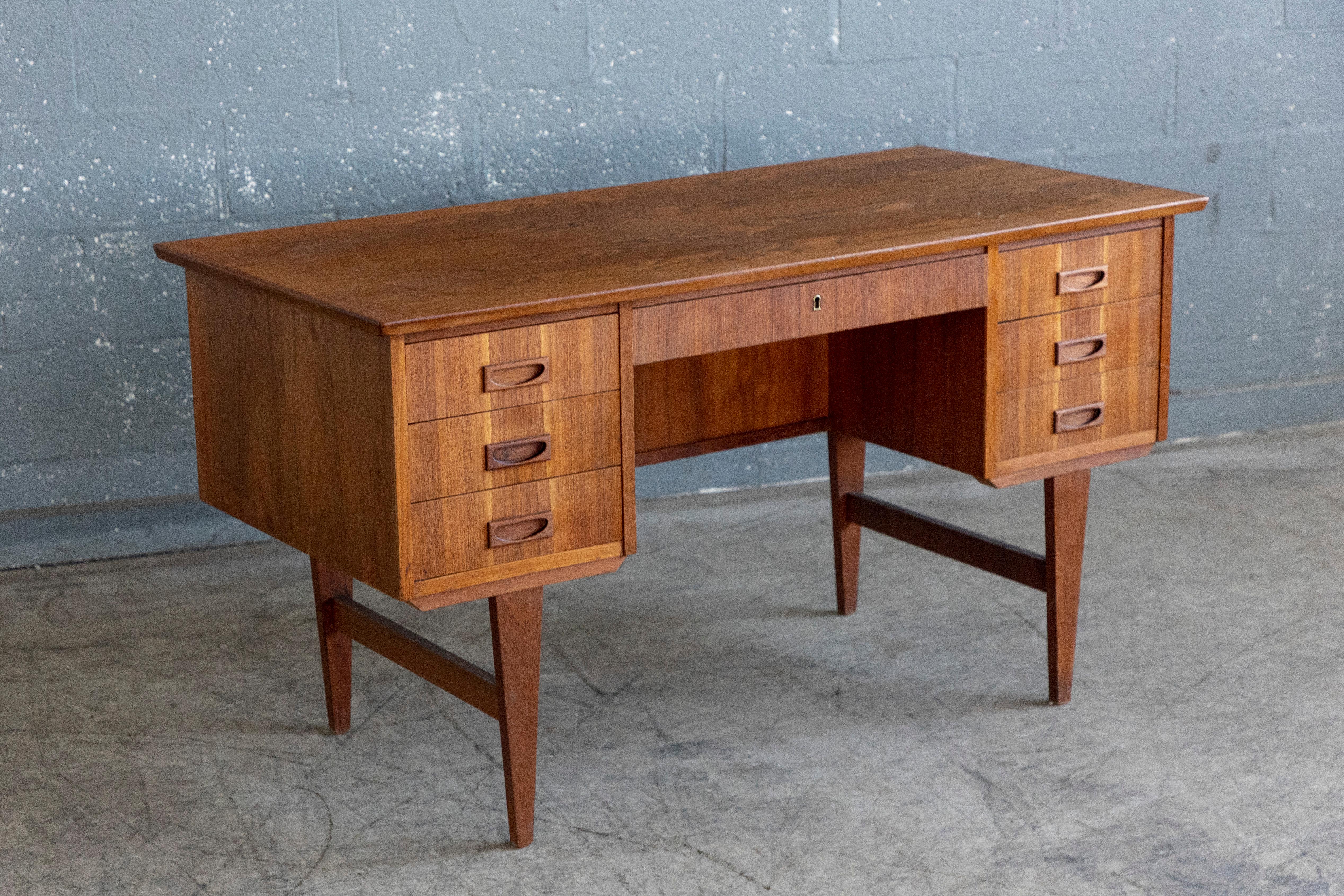 Beautiful Danish executive desk in the style of Kai Kristiansen and made in Denmark sometime in the late 1950's. Made from teak veneer and solid teak. This desk is slightly smaller than a traditional executive desk produced today and fits well in