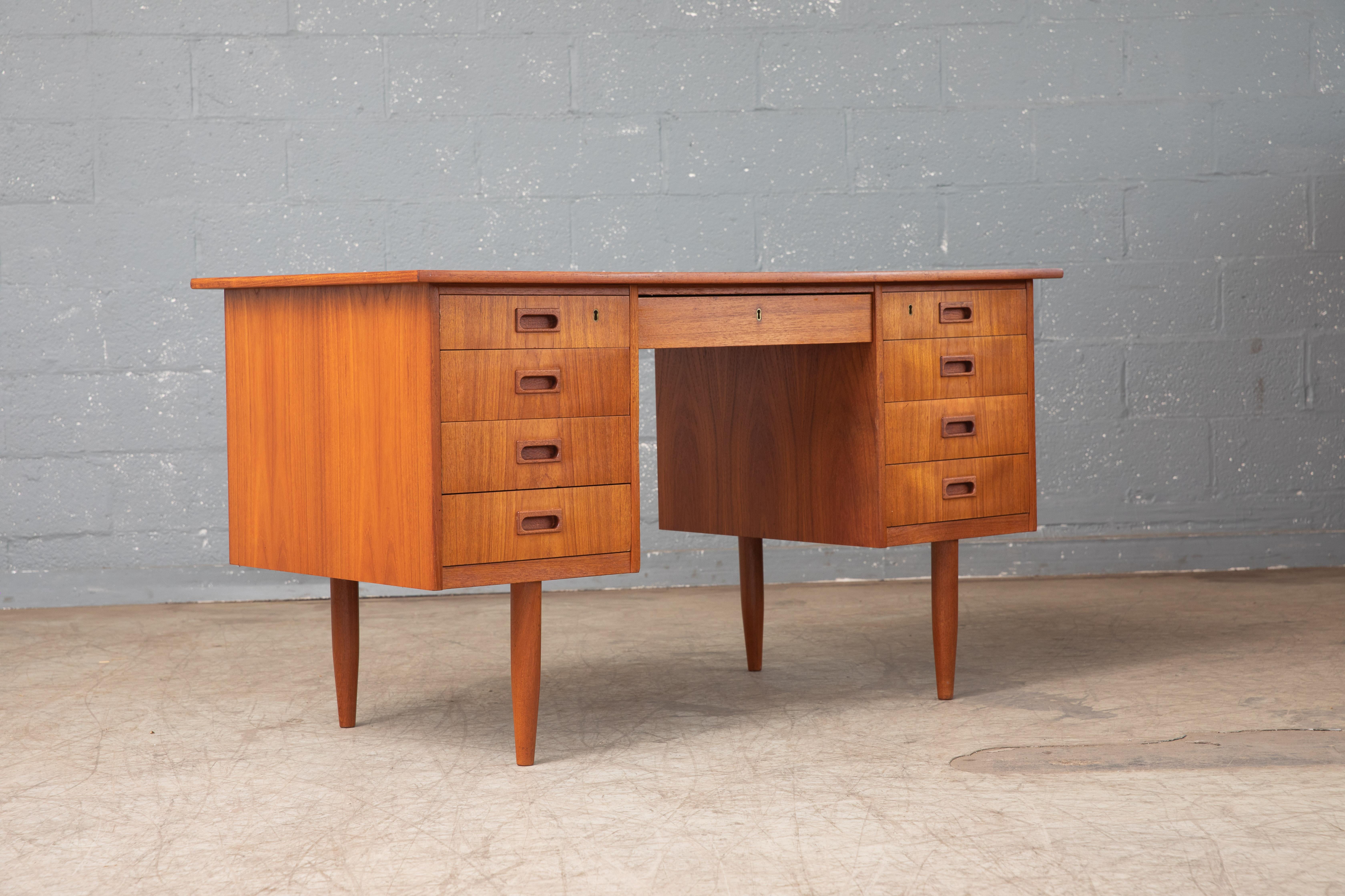 Beautiful Danish small executive desk in teak designed in the style of Kai Kristiansen and made in Denmark in the 1950-60s. Due to its size it's very versatile and fits well into urban Dwellings. Overall very good condition with the top showing a