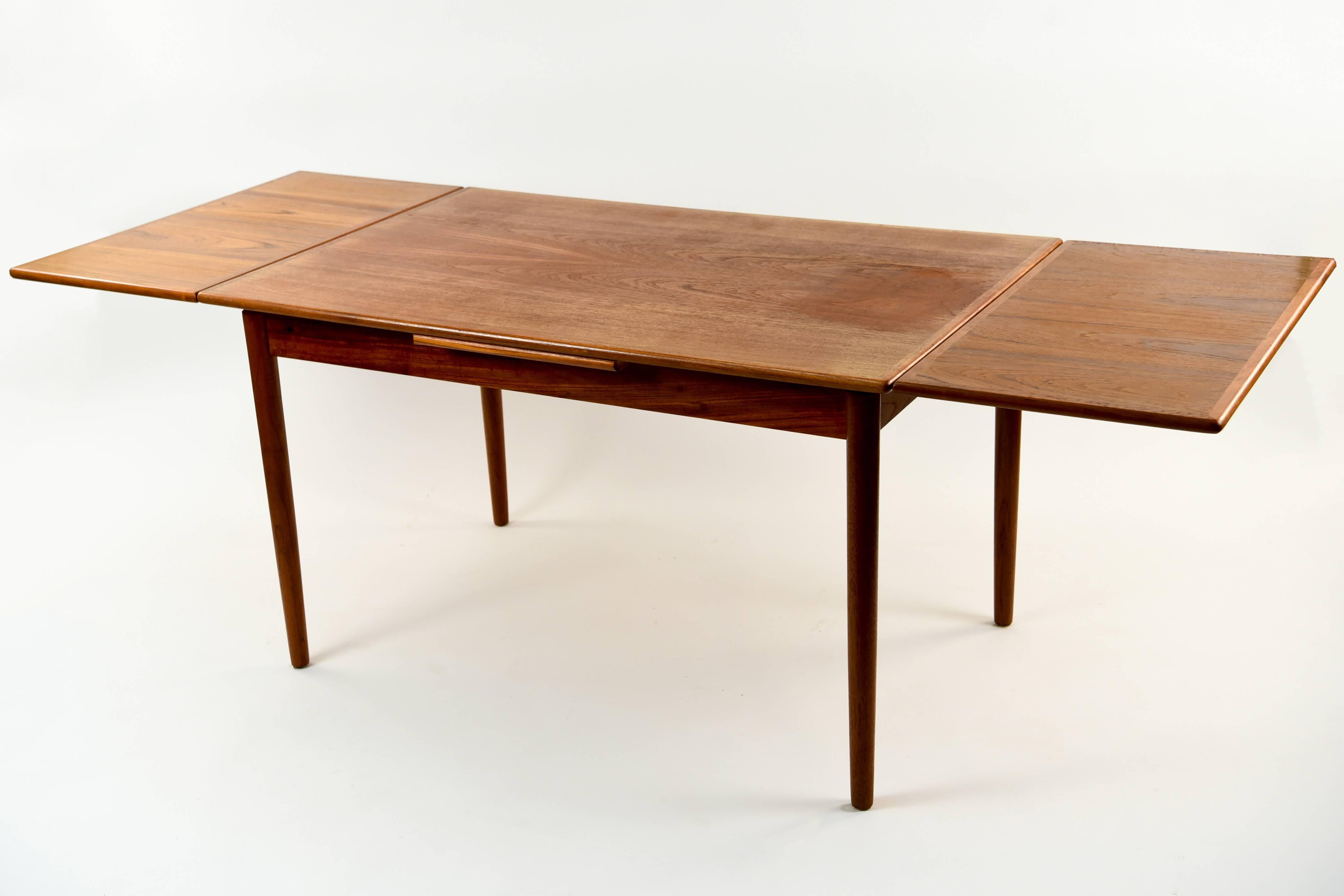 This Danish midcentury dining table is made of teak wood. With a simple yet pleasing form, this table would be a versatile addition into any interior. Features two pull out leaves that each add 17.25