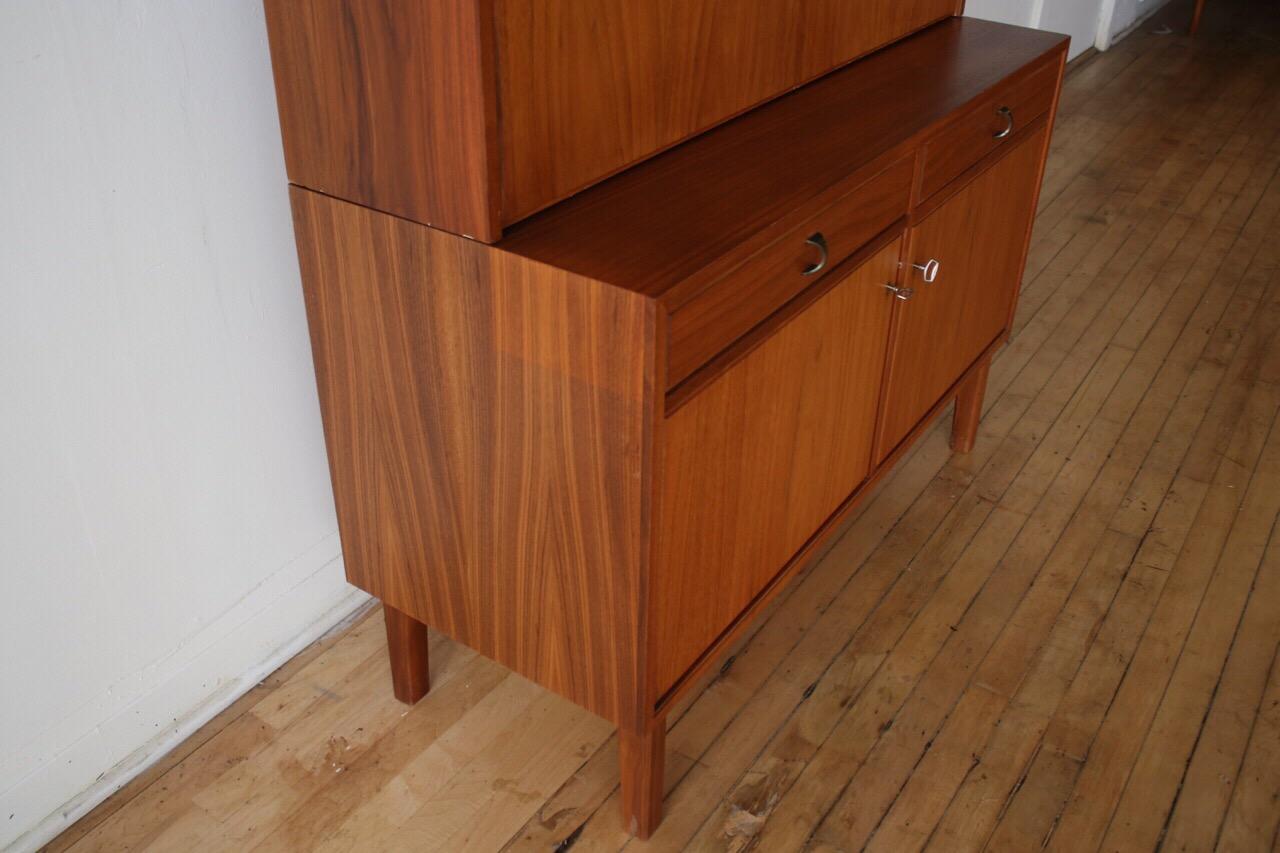 Midcentury Danish modern teakwood shelf.
Just imported from Copenhagen!
Two-piece unit.
Beautiful teak woodgrain throughout.
Comes with 3 keys.
Adjustable shelving.
Dovetailed drawers.
Drop-down bar has mirror and glass shelf.
Excellent