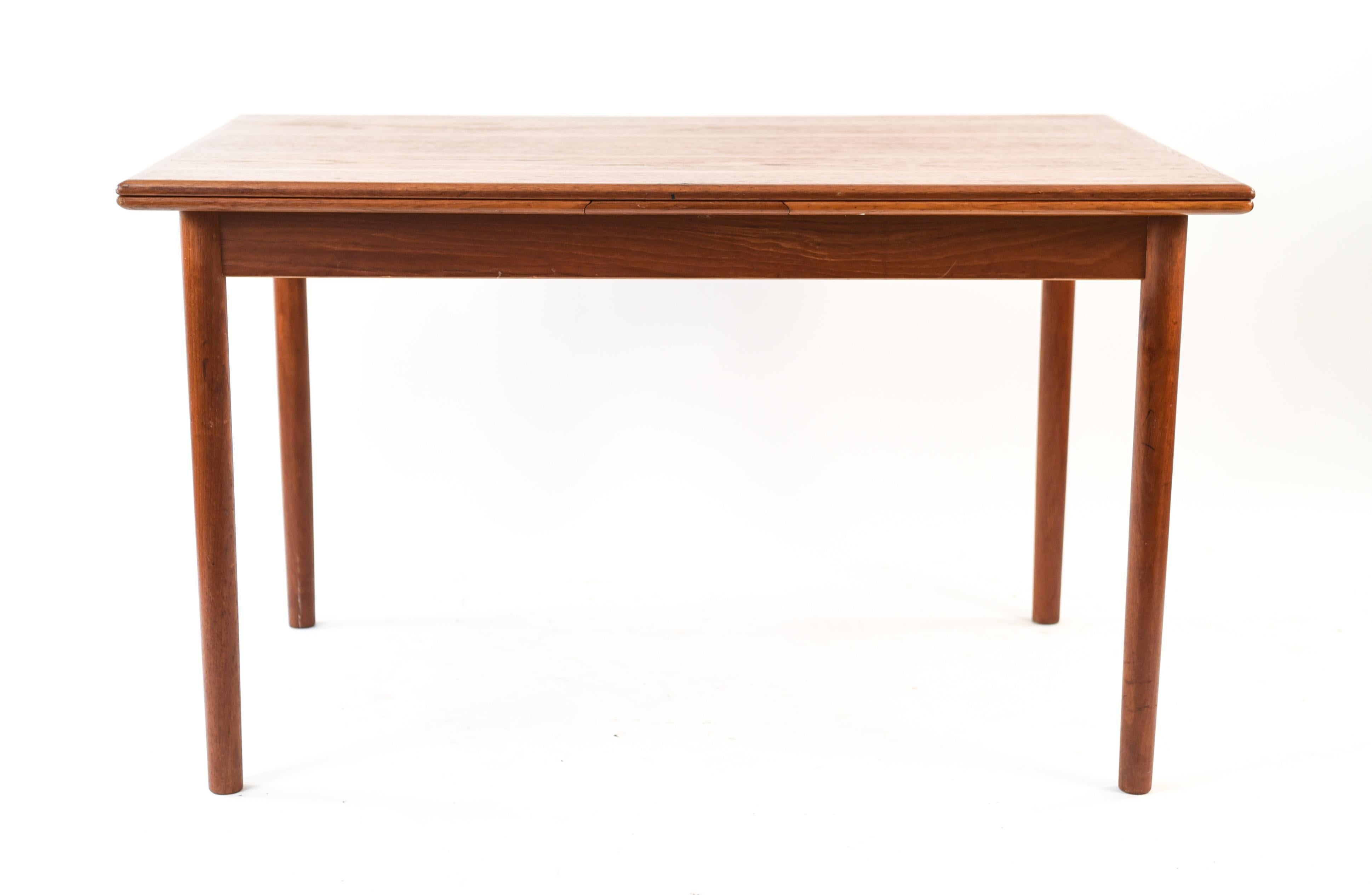 This Danish midcentury dining table is made of teak wood. A classic, Minimalist rectangular form that will complement any dining space. With two pull-out leaves.