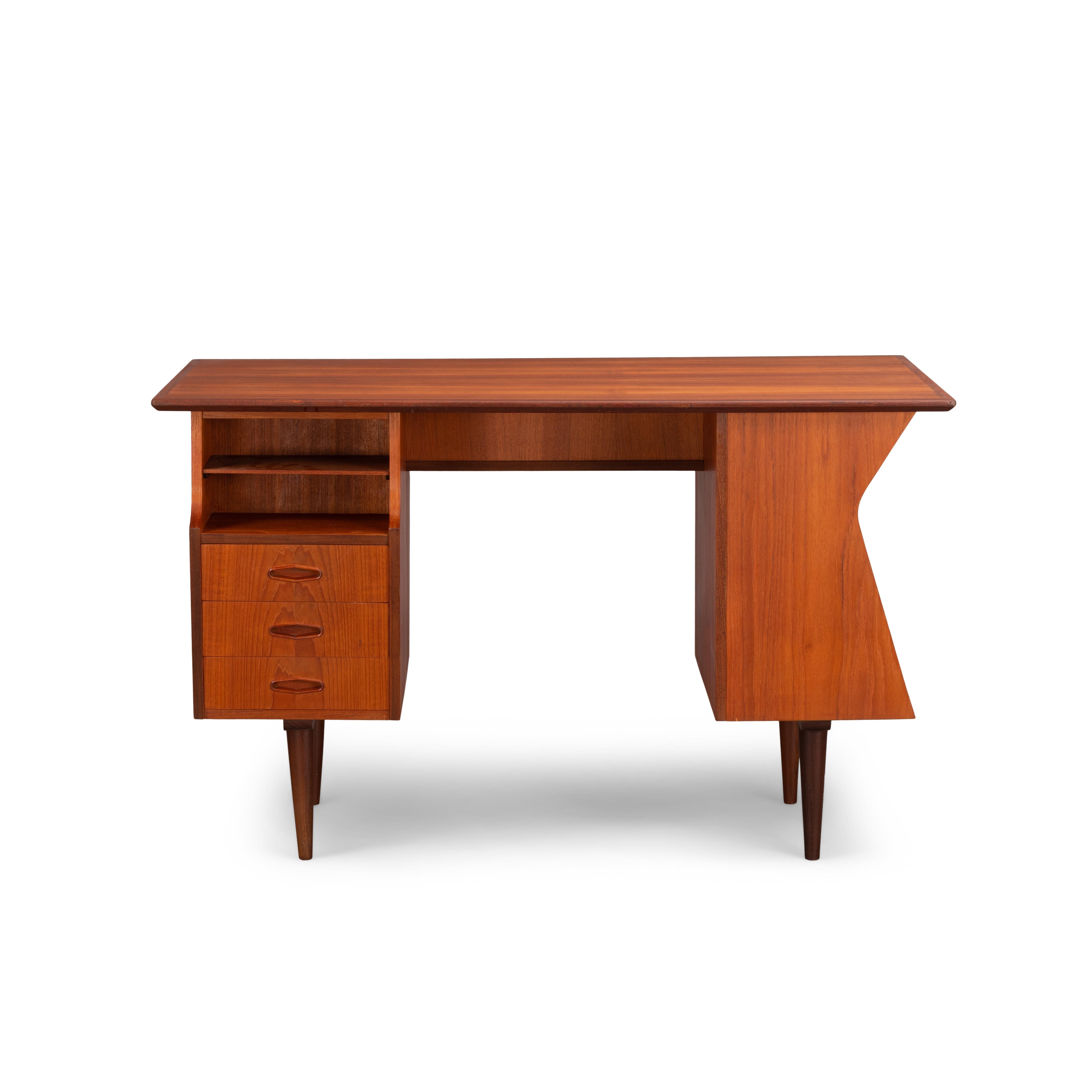 This Danish midcentury rare teak writing desk has been produced during the 1960s. It is made of teak with sculptural shape and handles. The desk features different storage possibilities with a total of five drawers. This bureau can be placed free