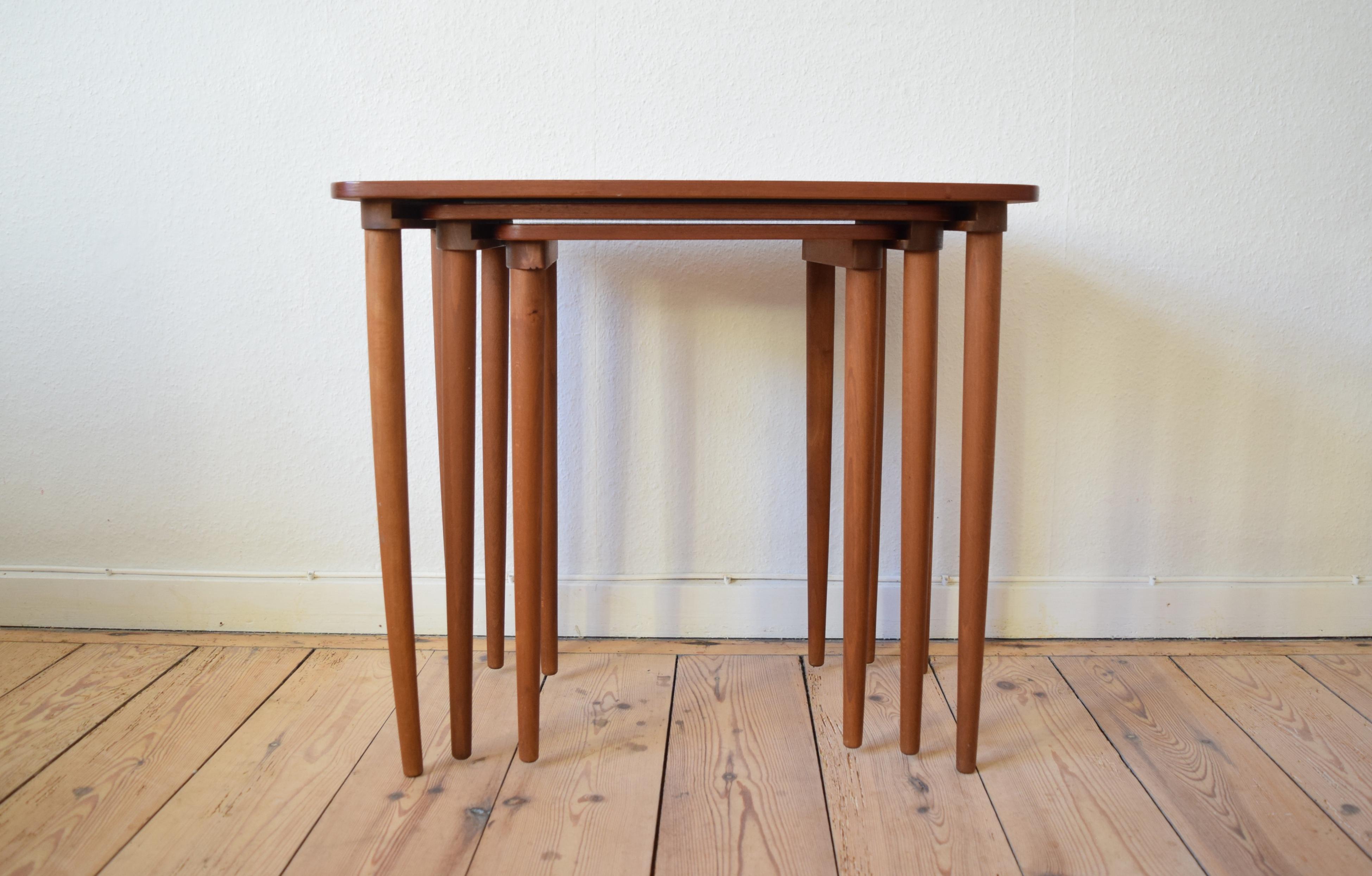 Teak nest of tables manufactured in Denmark in the 1950s-1960s. The tables 'nest' by means of a groove on the underside of the top-plates. There are very few marks on this set and the tables still have a dark red teak hue. We may be able to remove