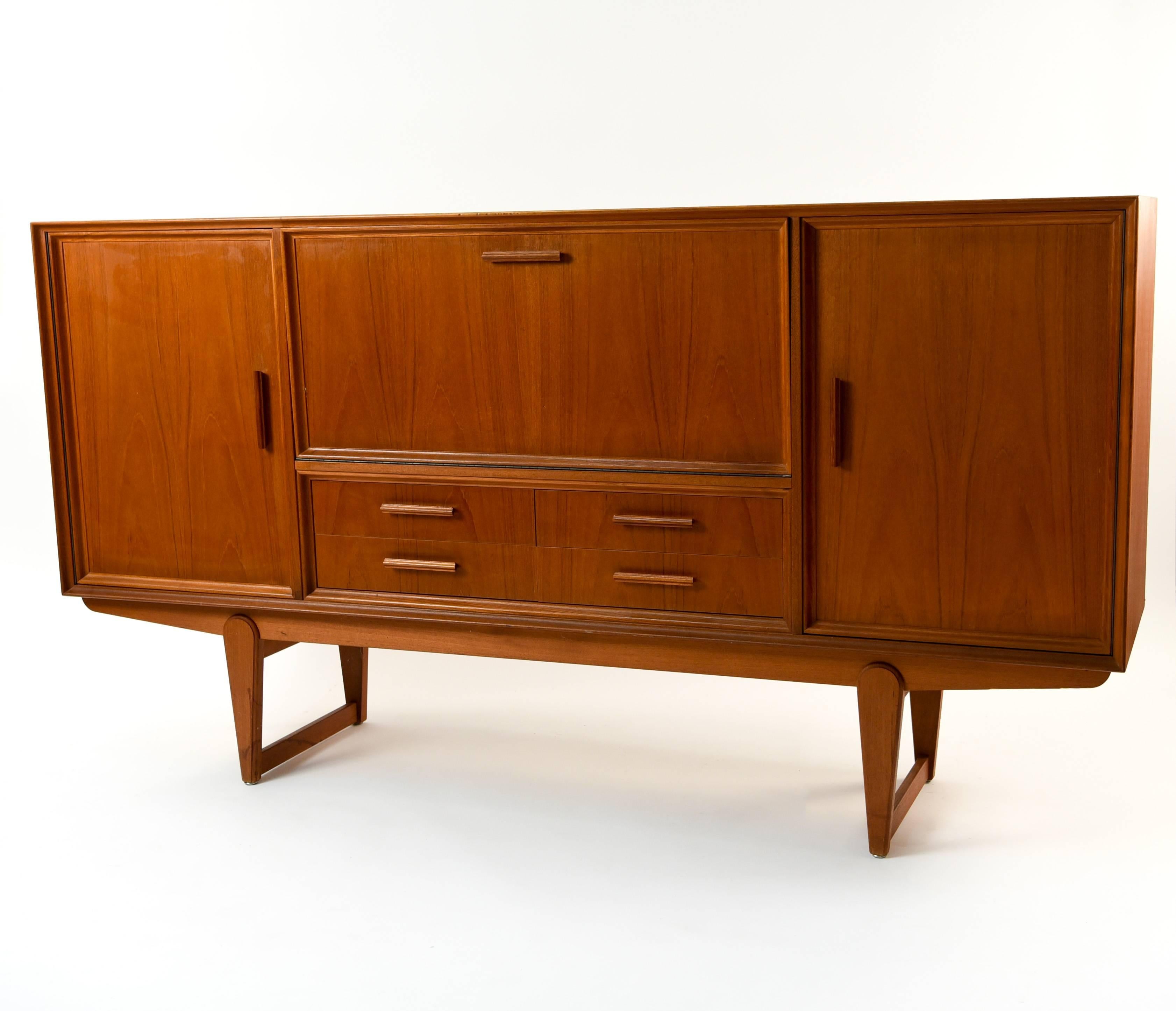 This Danish midcentury teak sideboard is full of functional, convenient storage compartments. The balanced layout of the drawers adds to the sturdy appearance.