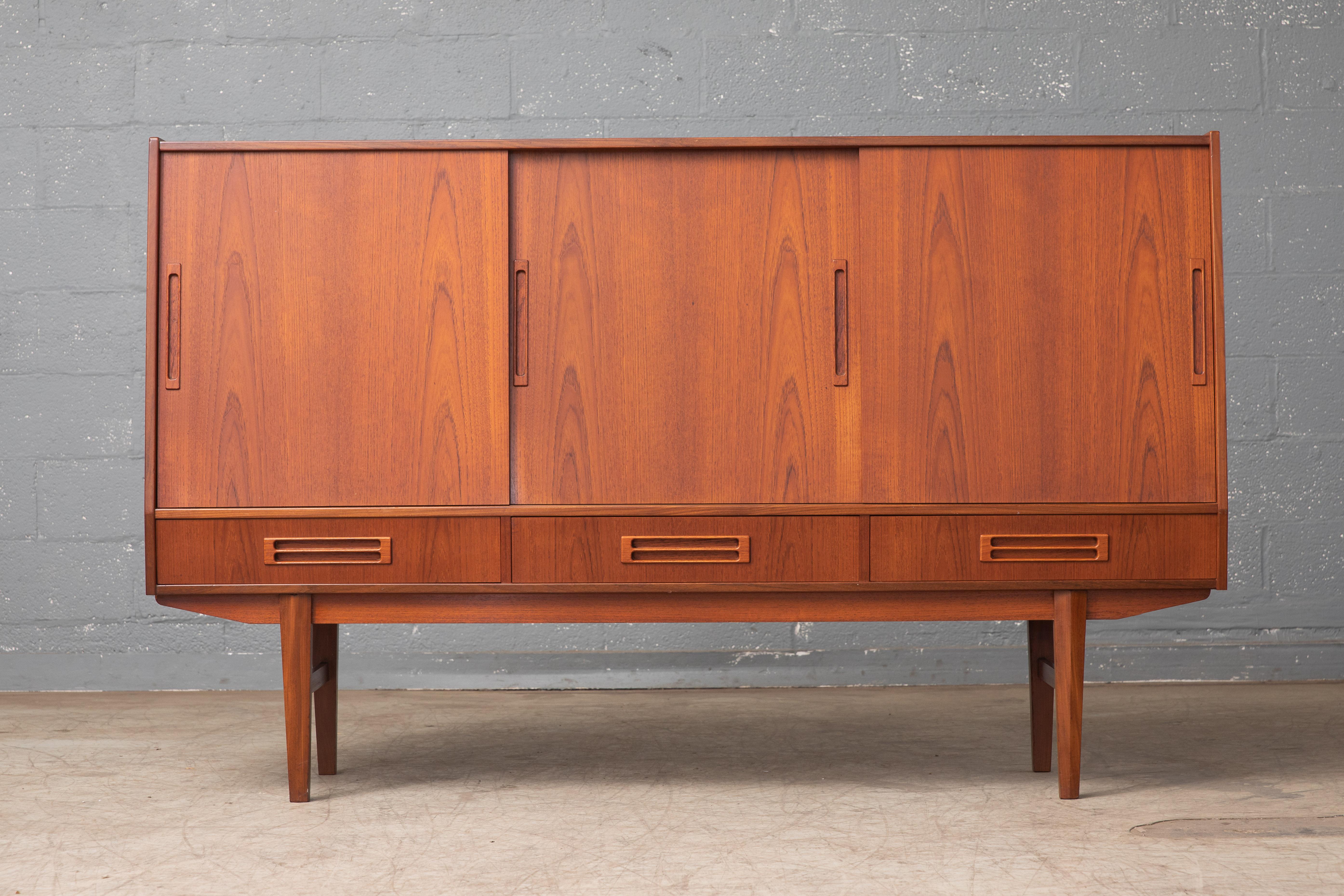 Fantastic Danish highboard manufactured in the late 1950s. Elegant timeless design piece with a nice size and presence about it without being too imposing. High caliber build quality with all edges in thick solid teak. Nice beautiful rosewood bar