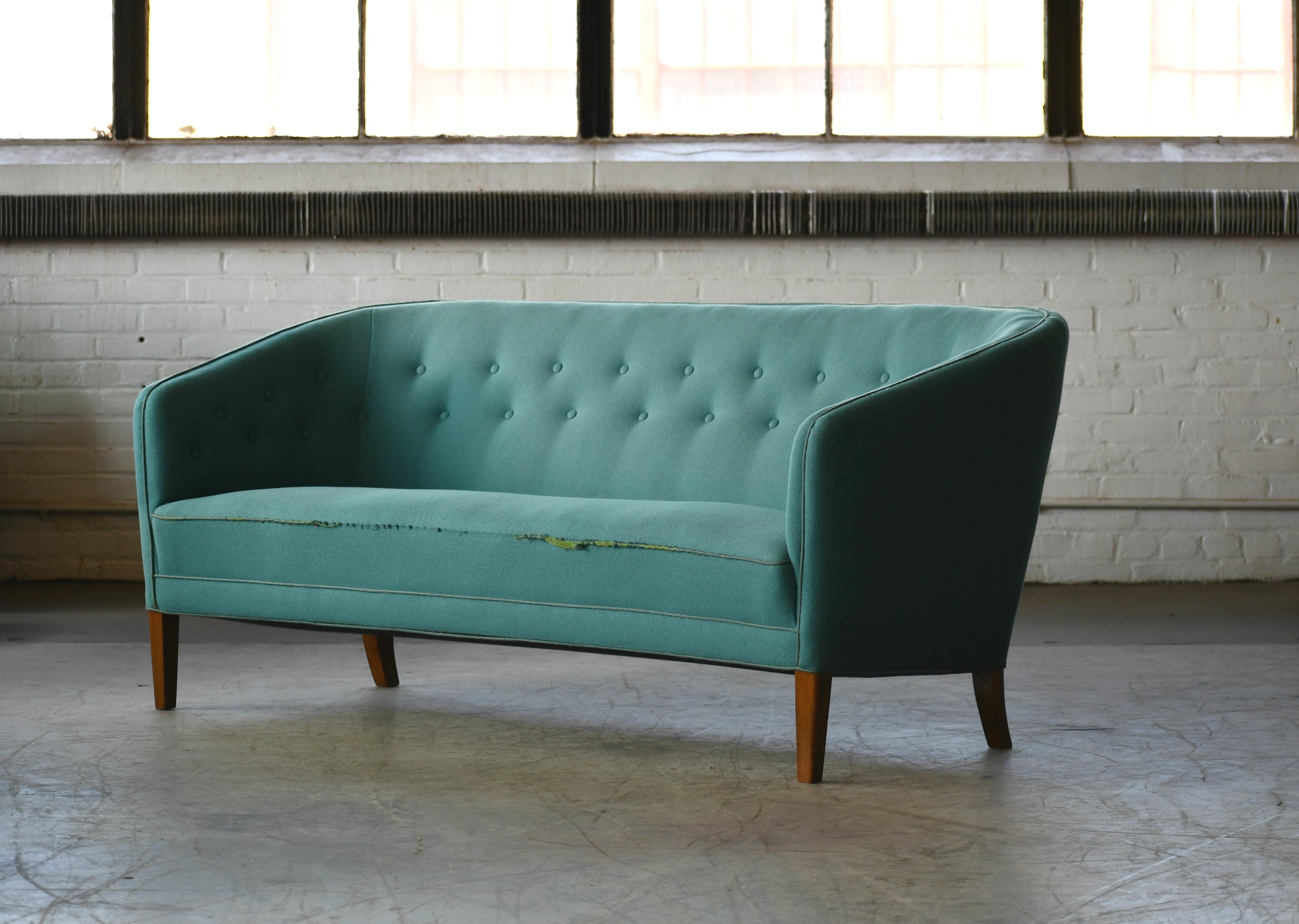 Beautiful sought after three-seat sofa by Ludvig Pontoppidan made in Denmark probably between late 1940s and 1950. The design is a classic Pontoppidan with slim elegant scoop-like lines and a very modern look way ahead of its time. The sofa is solid
