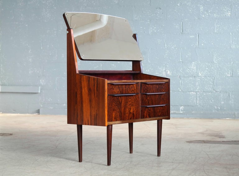 Elegant Danish rosewood vanity from the 1950s made from solid rosewood and rosewood veneer. Small cabinet with five nice drawers for easy organization. Nice rosewood veneer with great color and grain and pulls carved from solid rosewood. A little