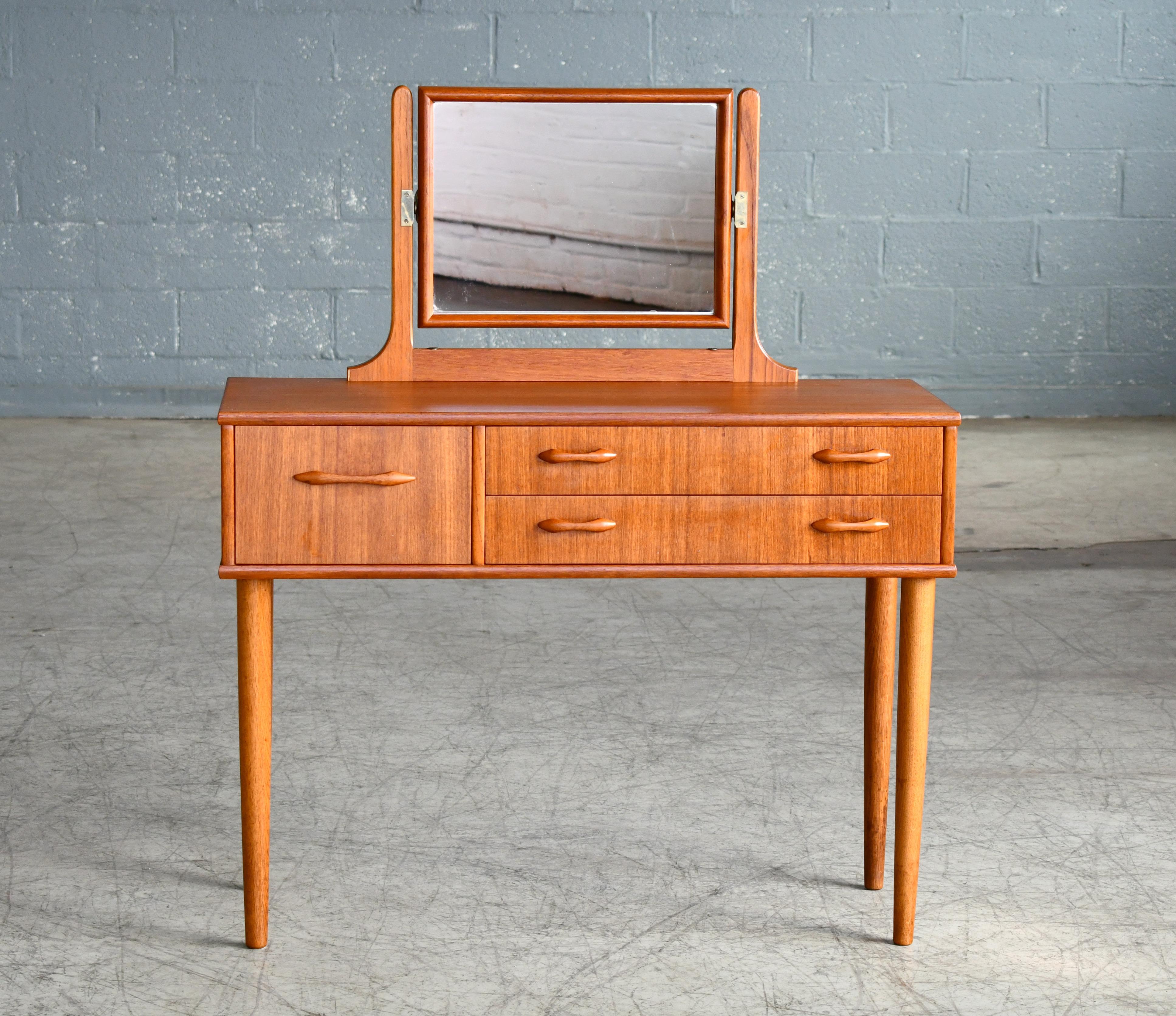 Elegant Danish teak vanity from the 1960s made from solid teak and teak veneer. Small cabinet with five nice drawers for easy organization. Great color and grain and pulls carved from solid teak. Very minor signs of wear - overall very good