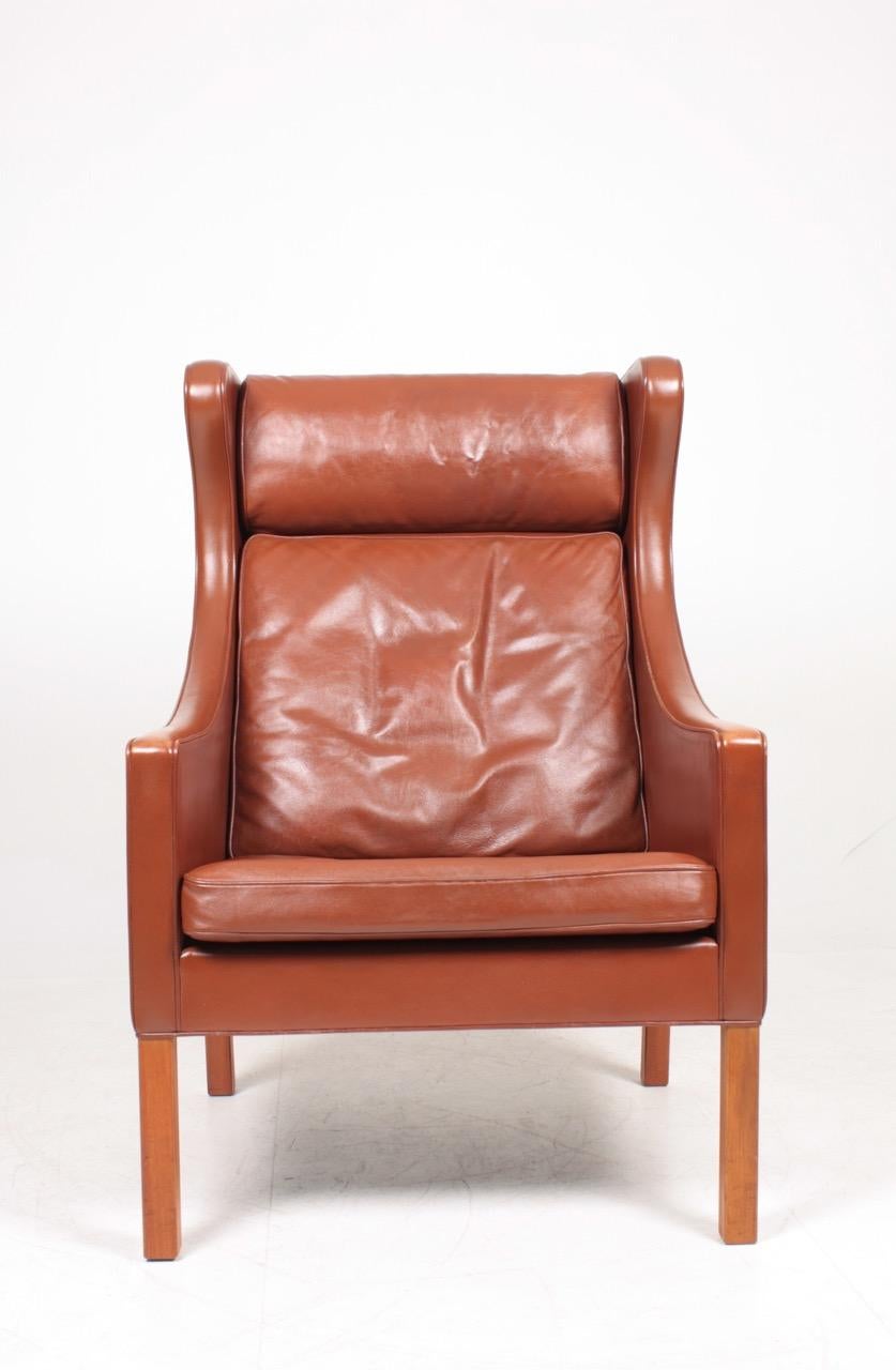 Wing back chair in patinated leather, model 2204 designed by MAA. Børge Mogensen for Fredericia Møbelfabrik. Outstanding quality and very comfortable. Great original condition.
