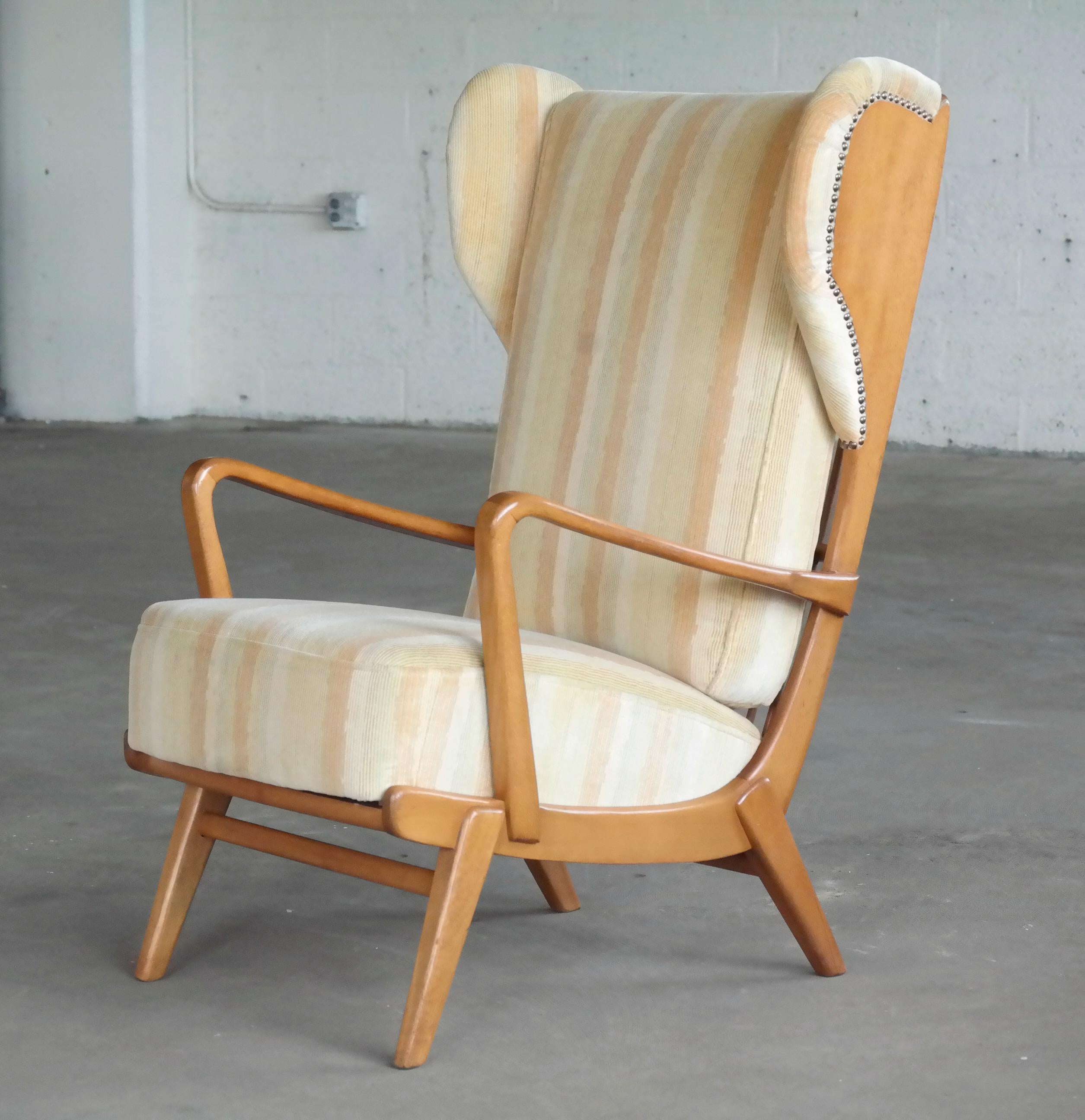 Ultra cool Scandinavian high back wing chair with exposed sides made from elm wood by an unknown maker circa 1950s. We found this cool chair in Copenhagen and while it is unmarked we suspect it could well be of Swedish manufacture. The fabric is in