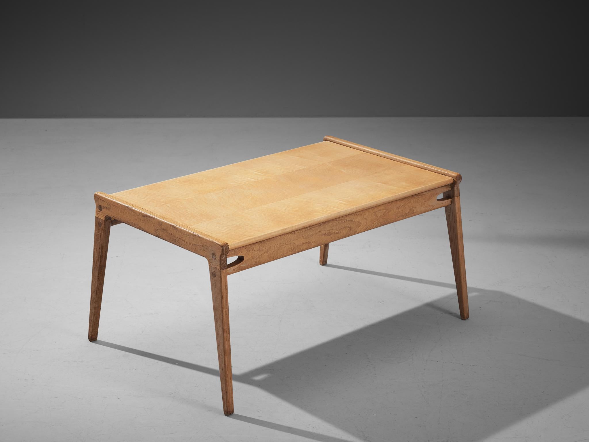 Coffee table, maple, oak Denmark, 1960s

This cocktail table of Danish origin has a splendid construction that embodies a simplistic, natural and timeless aesthetic. A unique detail to the design are the small cut outs on each side just below the