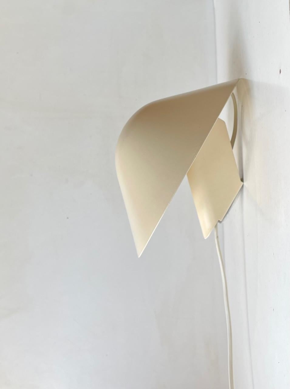 Off-white creamy version of the Zephyr wall light made by Lyfa/Lyskær in Denmark during the 1980s. Very similar design to Poul Henningsen's PH hat. The shade is adjustable up/down and it features an on/of switch to its cord. Measurements: Diameter: