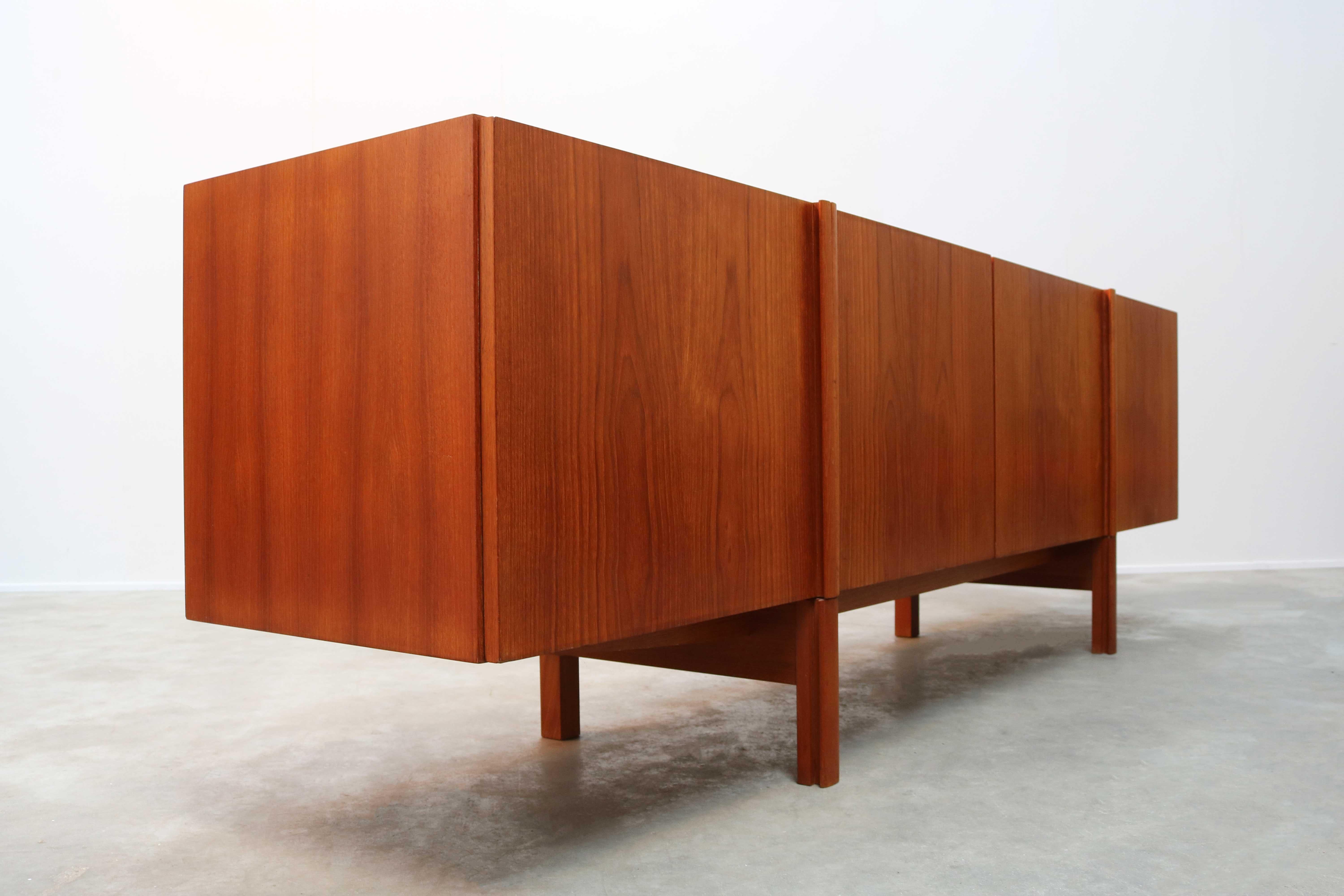 Rare Minimalist Danish design sideboard in teak by IB Kofod-Larsen for Faarup Møbelfabrik, 1960. The sideboard has a unique design that merges the legs with the door handles into a single line, resulting in a gorgeous Minimalist front. Warm and