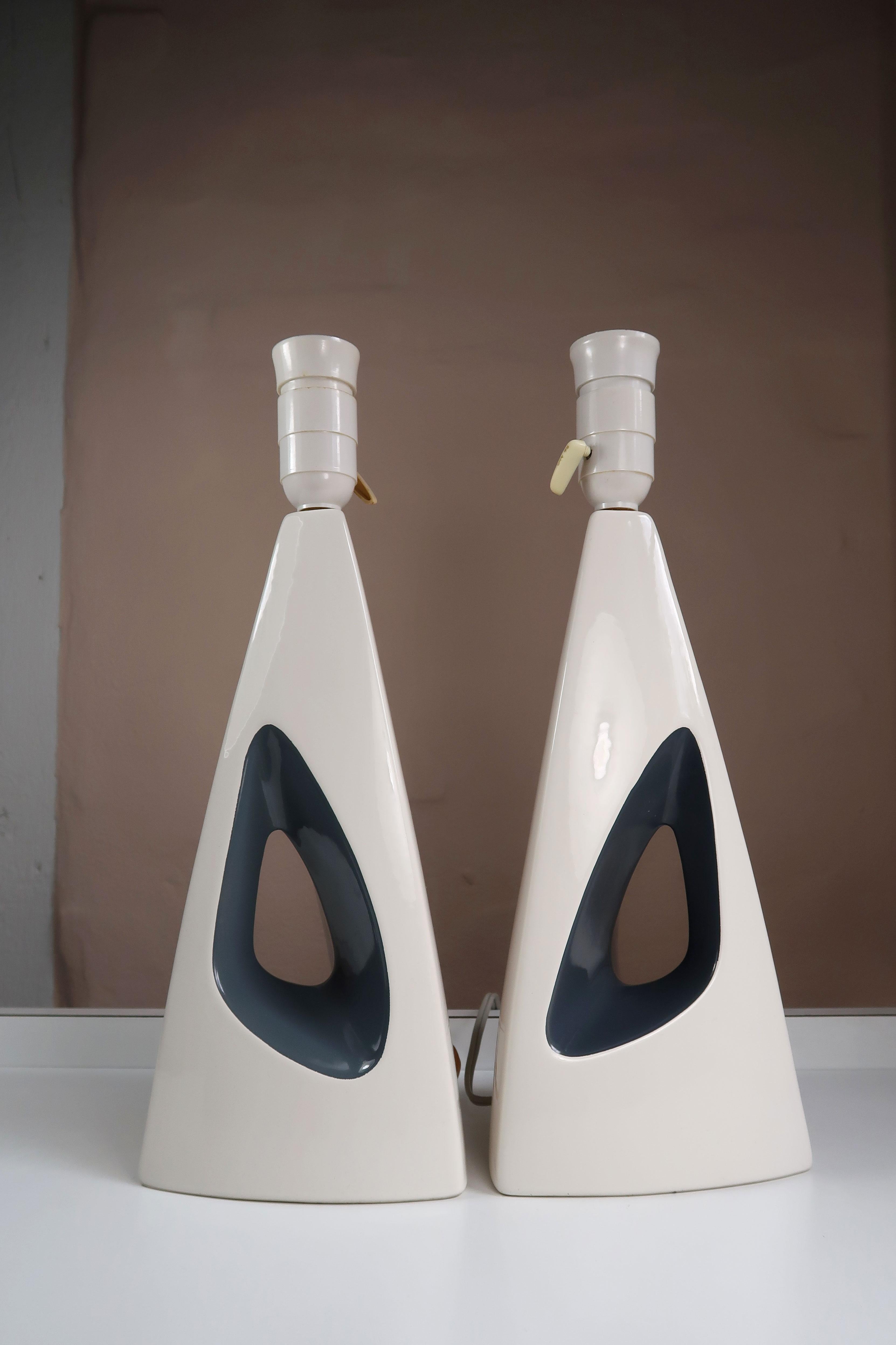 Two elegant handmade triangular, two colored Danish midcentury modern table lamps. Glossy warm white glaze with shiny anthracite grey in the handle or hole in the middle. Attributed to acclaimed Danish designer Svend Aage Holm Sørensen and