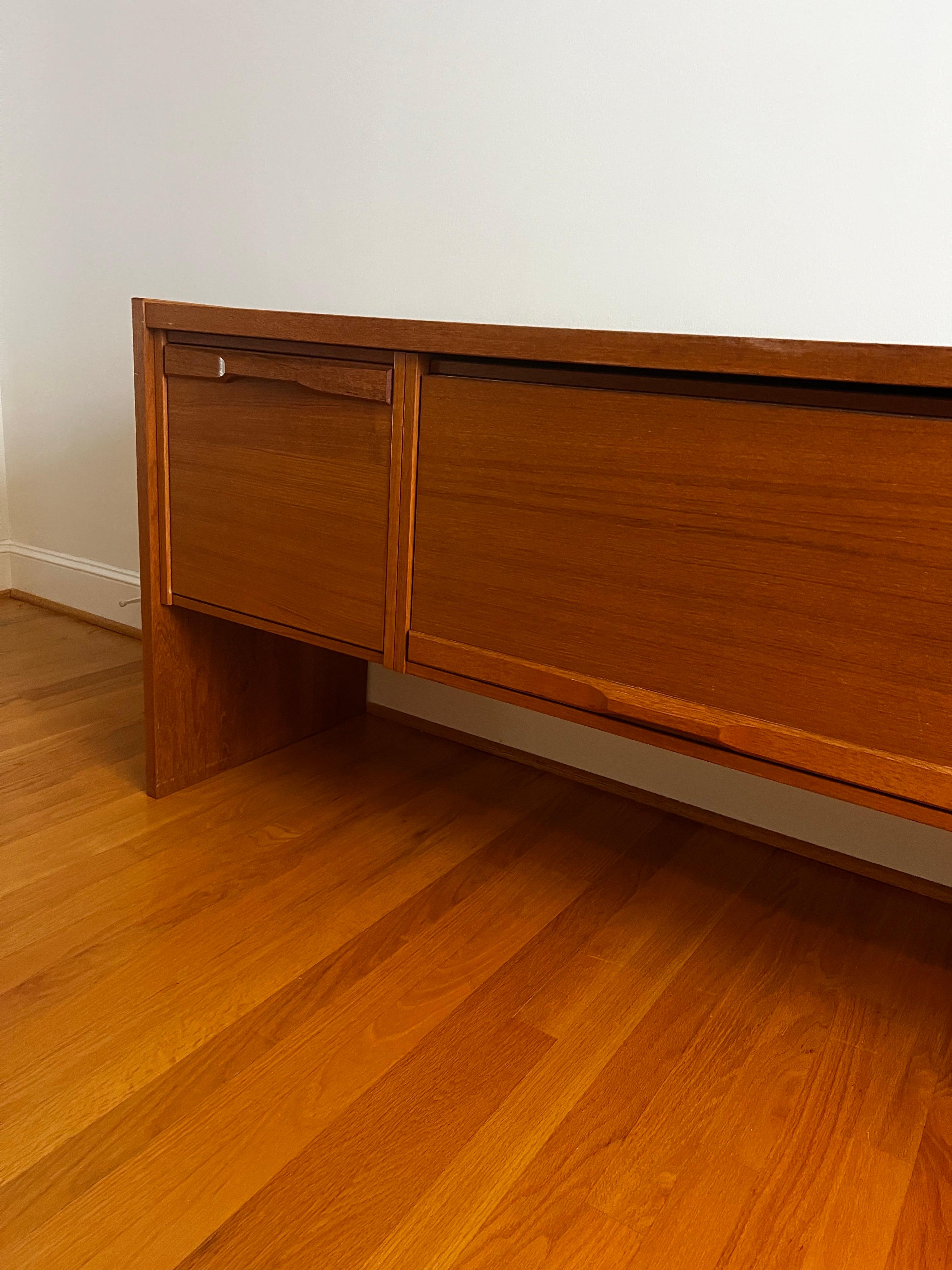Mid Century Modern Mobler Teak Cabinet. 

Denka - Made in Denmark. 
Very solid and smooth drawers/door.   Center door goes up.  Side doors are drawers with file folder bars. 