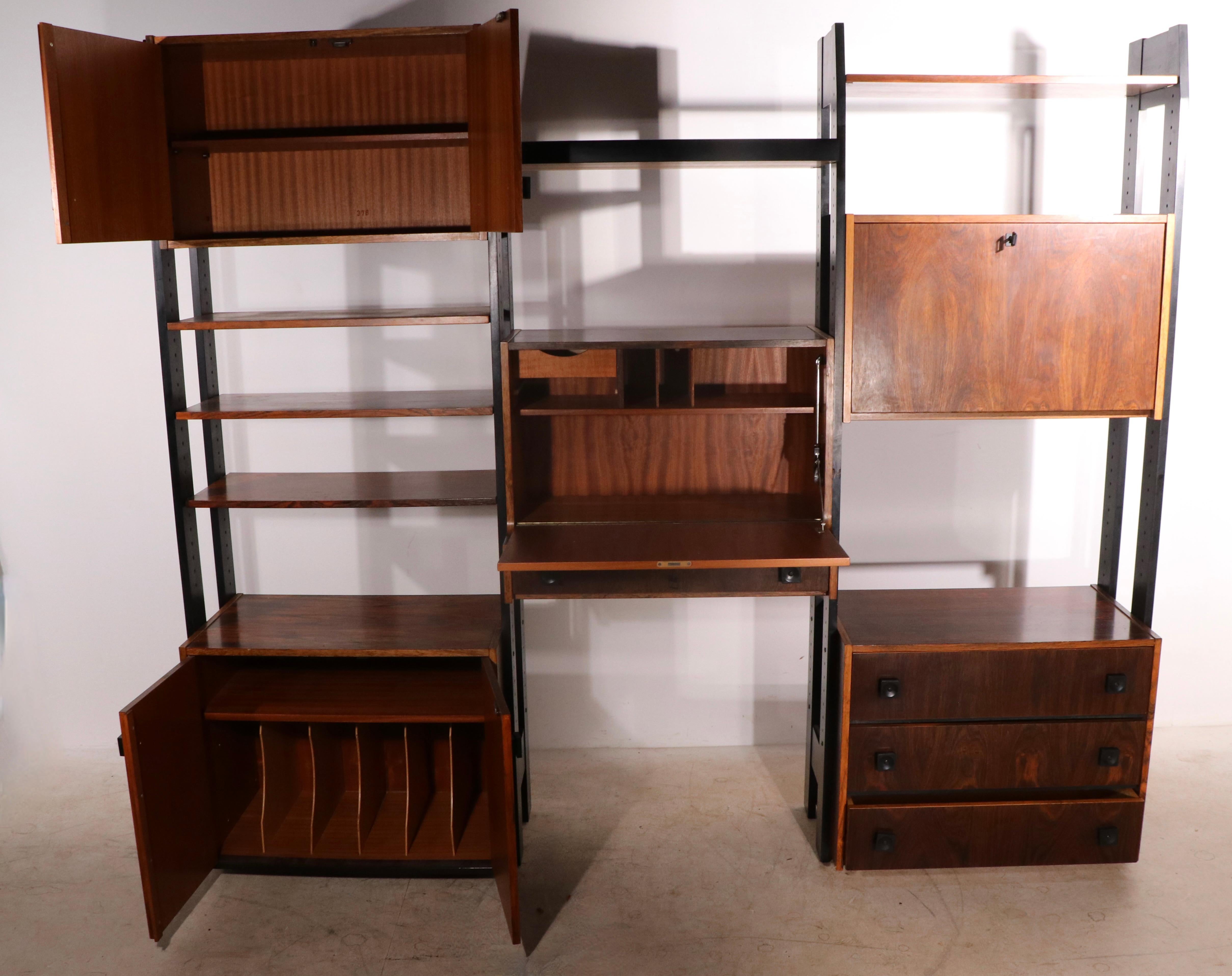 Exceptional Danish Mid-Century Modern freestanding wall unit having 3 bays, including ( 5 ) rosewood cabinets and ( 5 ) rosewood shelves, with original black paint finished solid wood vertical supports. and black handles. The cabinets include a fall