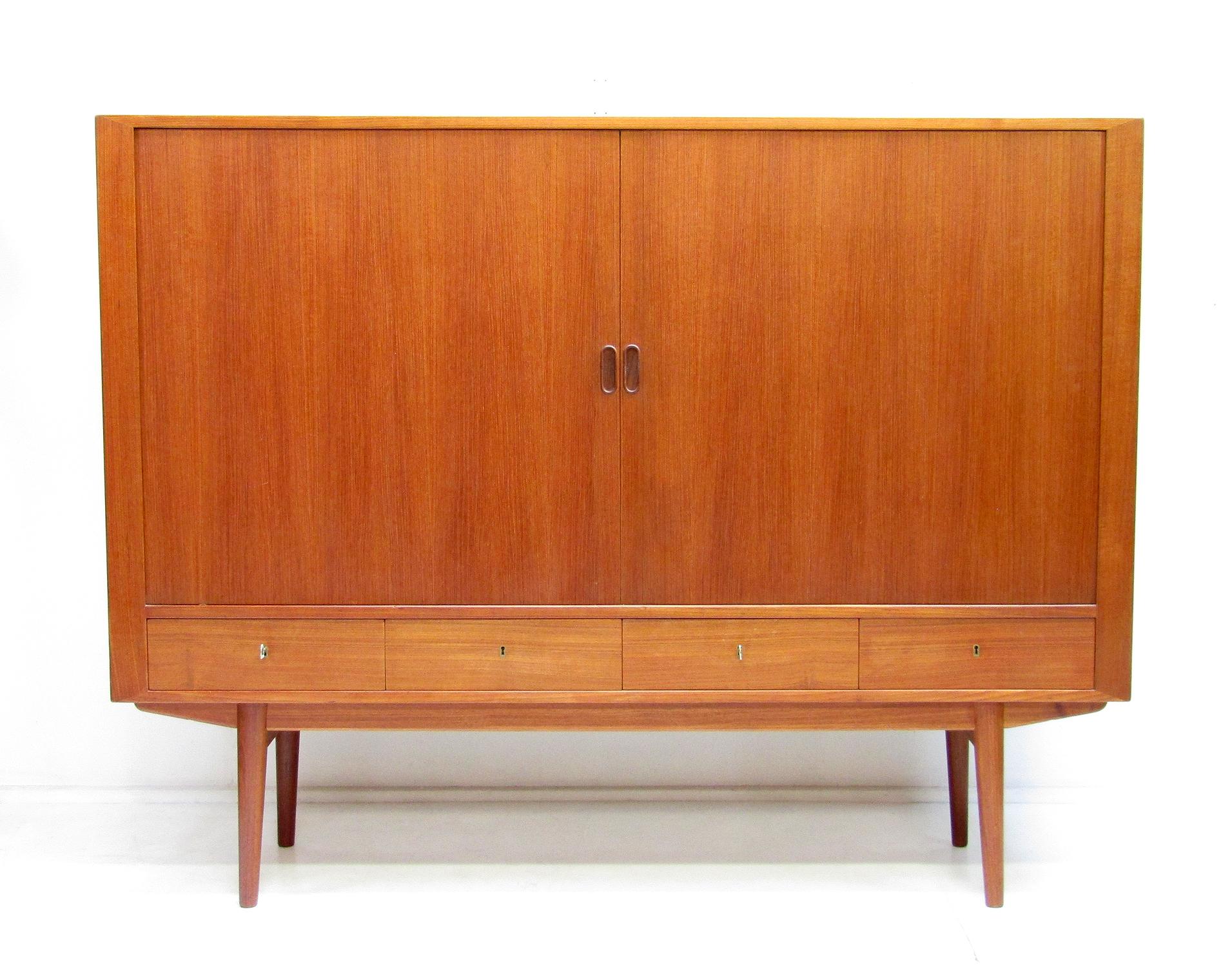 A sleek 1960s highboard in warm teak by Arne Vodder for Sibast.

With sliding tambour doors, tapered legs, copious storage and perfect proportions it is both visually arresting and extremely useful.

The Sibast label is affixed to the rear.

The