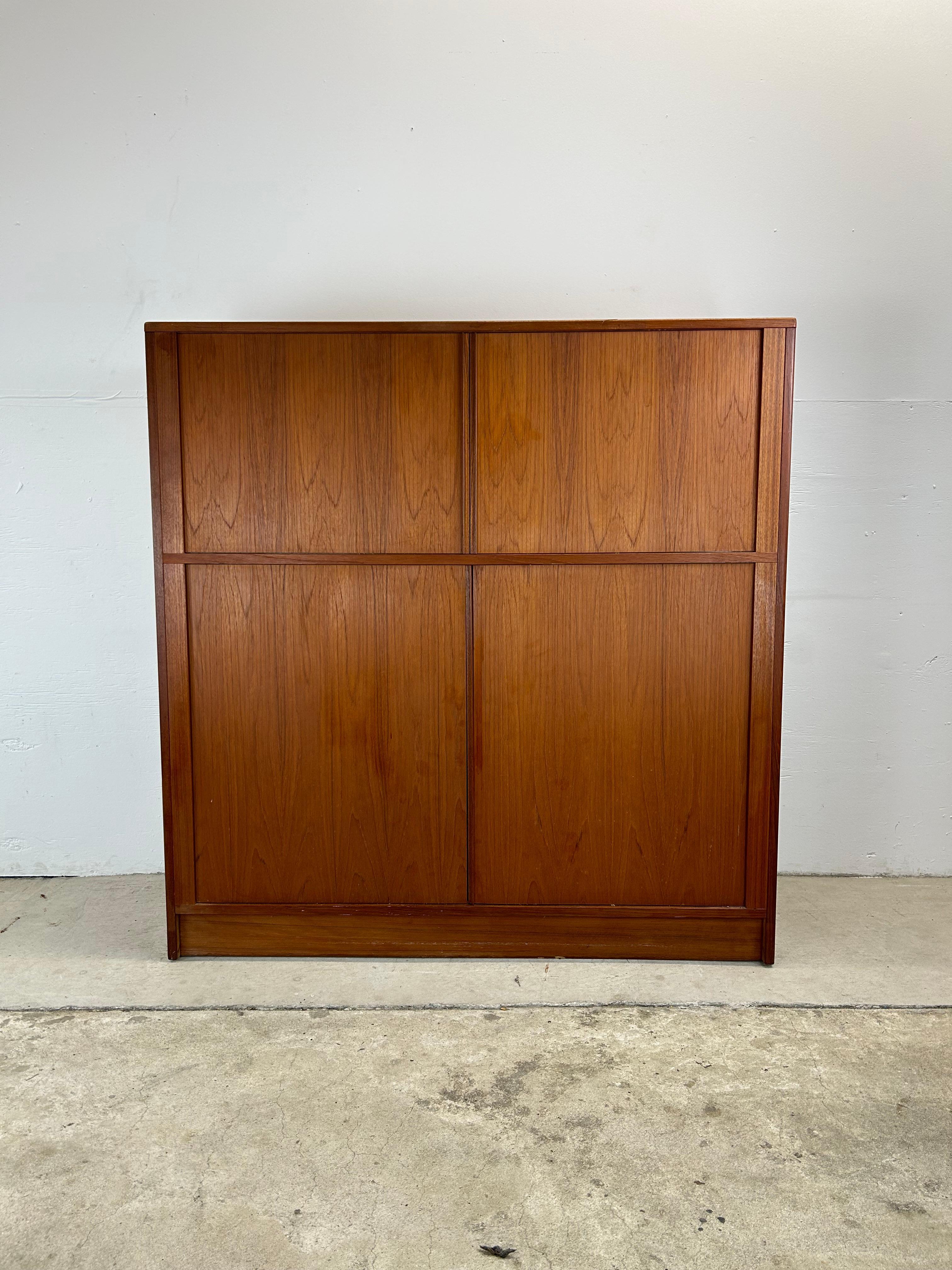 This Danish Modern Gentleman's chest features pressed wood construction, teak veneer with original finish, 4 tambour doors (2 top, 2 bottom), eleven dovetailed drawers across the bottom, and two adjustable shelves up top.

Complimentary pair of