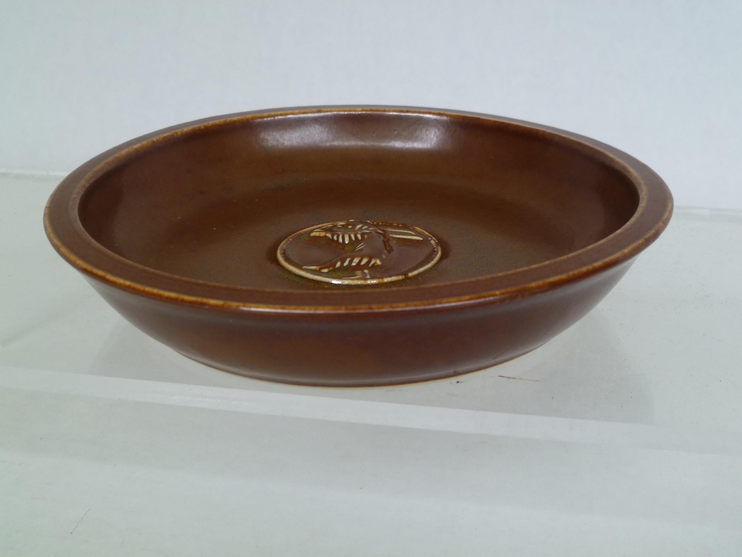 Danish modern 1954 stoneware dish by Saxbo Pottery. In a lovely warm brown color this small shallow bowl is decorated with the relief of upright bear carrying a tree trunk in the center

Incised on bottom 1854-1954 SAXBO

Measurements: 6 inches