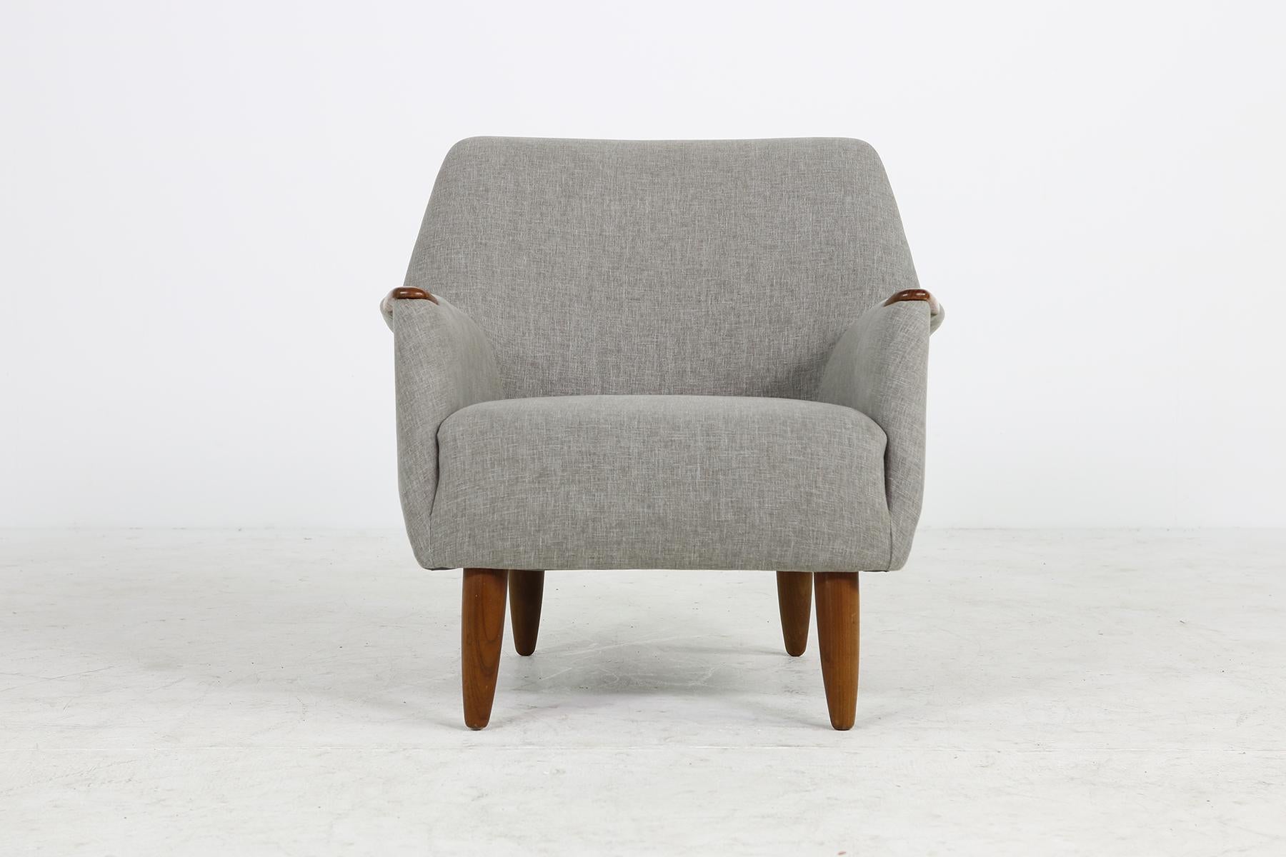 Beautiful and rare Danish modern 1960s armchair, lounge chair, design attributed to Kurt Ostervig, reupholstered and covered with new grey woven fabric, solid teak legs, nice details like the teak armrest end pieces, very good condition, since