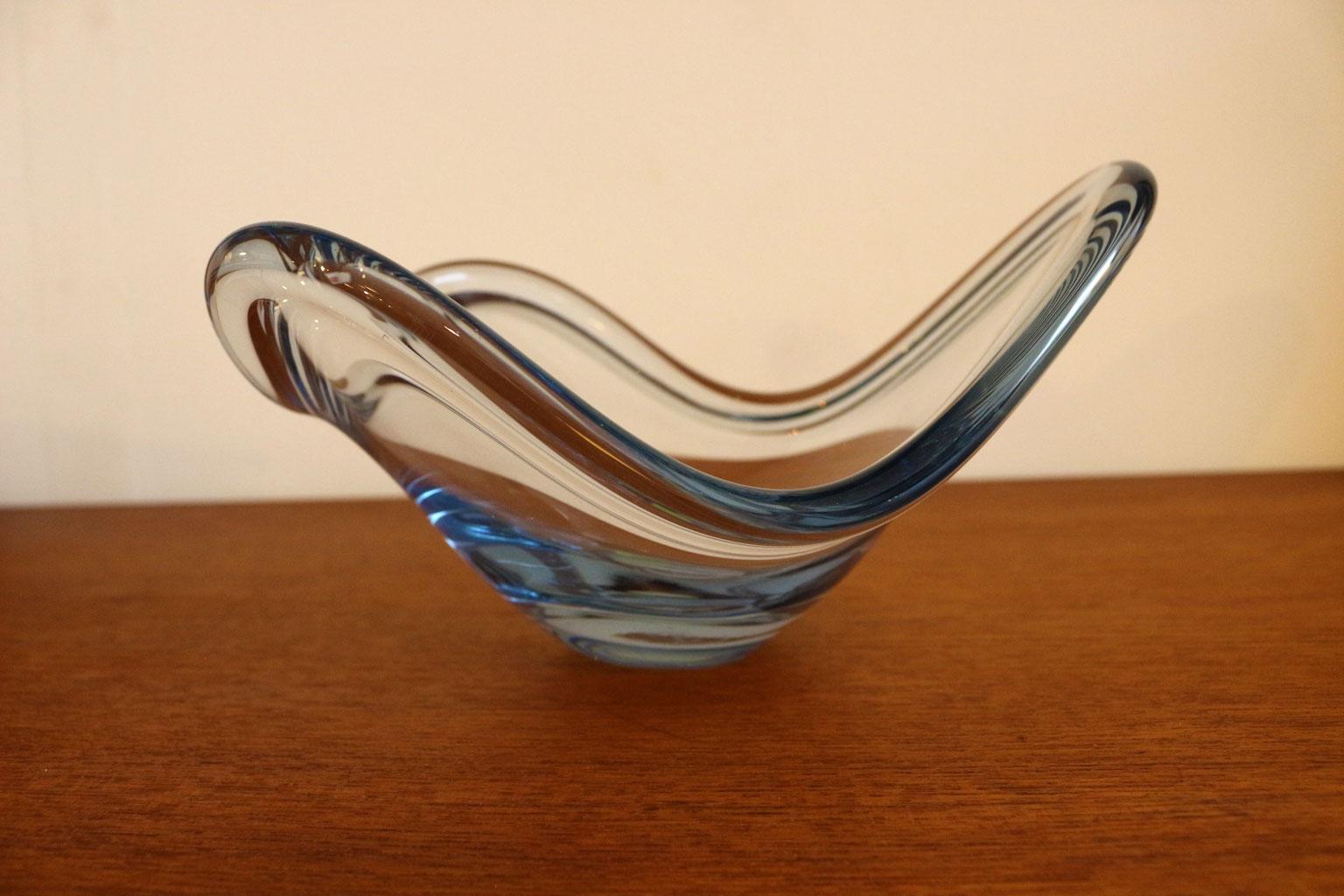 Oblong and irregular in shape this coveted Holmegaard 3 Swoop Dish is made of blown glass and has the faintest sky blue tint. A quality piece of decorative midcentury glass that would look great displayed on a coffee table or credenza.