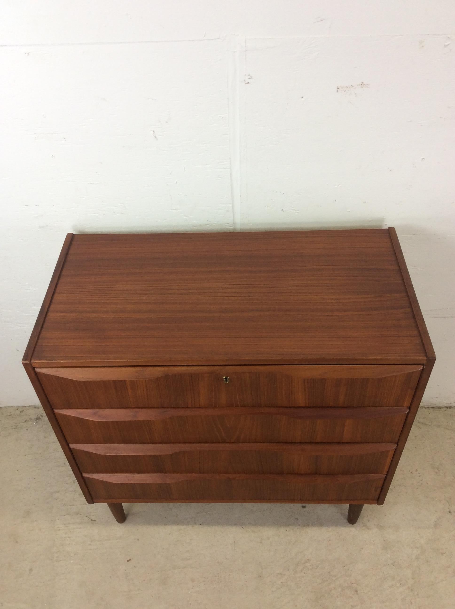 This danish modern chest of drawers features hardwood construction, teak veneer with original finish, four dovetailed drawers with unique wood pulls, brass lock with key, and tall tapered legs.

Dimensions: 31.25w 16.5d 31.25h

Condition notes: