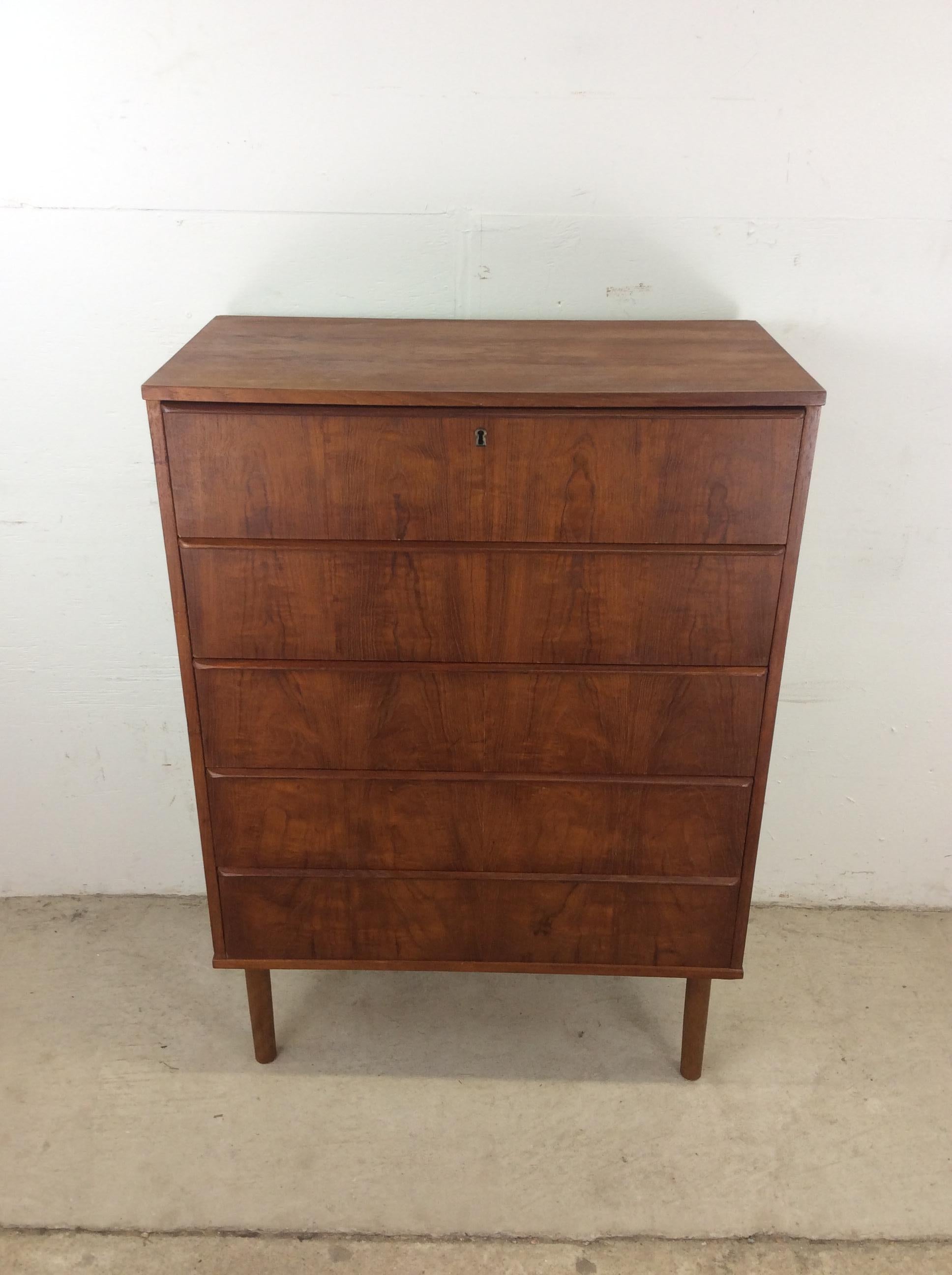 Questo comò danese moderno è costruito in legno massiccio, impiallacciato in teak con finitura originale, con cinque cassetti a coda di rondine con tiretti in legno, serratura in ottone con chiave funzionante e alte gambe affusolate.

Dimensioni: