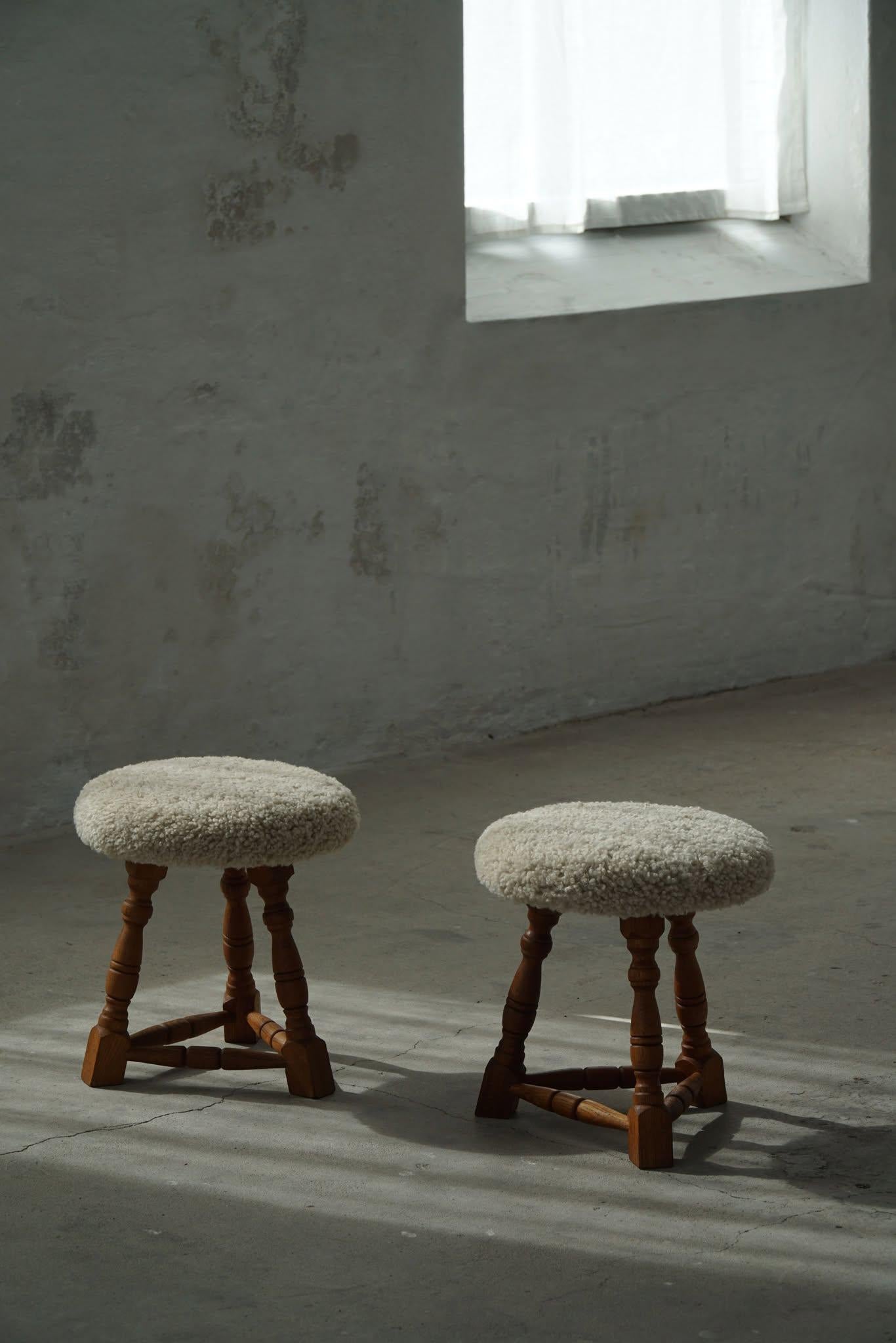 A pair of charming Danish modern stools in solid oak with curly legs, the round  seats are reupholstered in a great quality shearling lambswool. Made by a Danish Cabinetmaker in the 1950s. A rare pair with an intriguing impression.

A great object