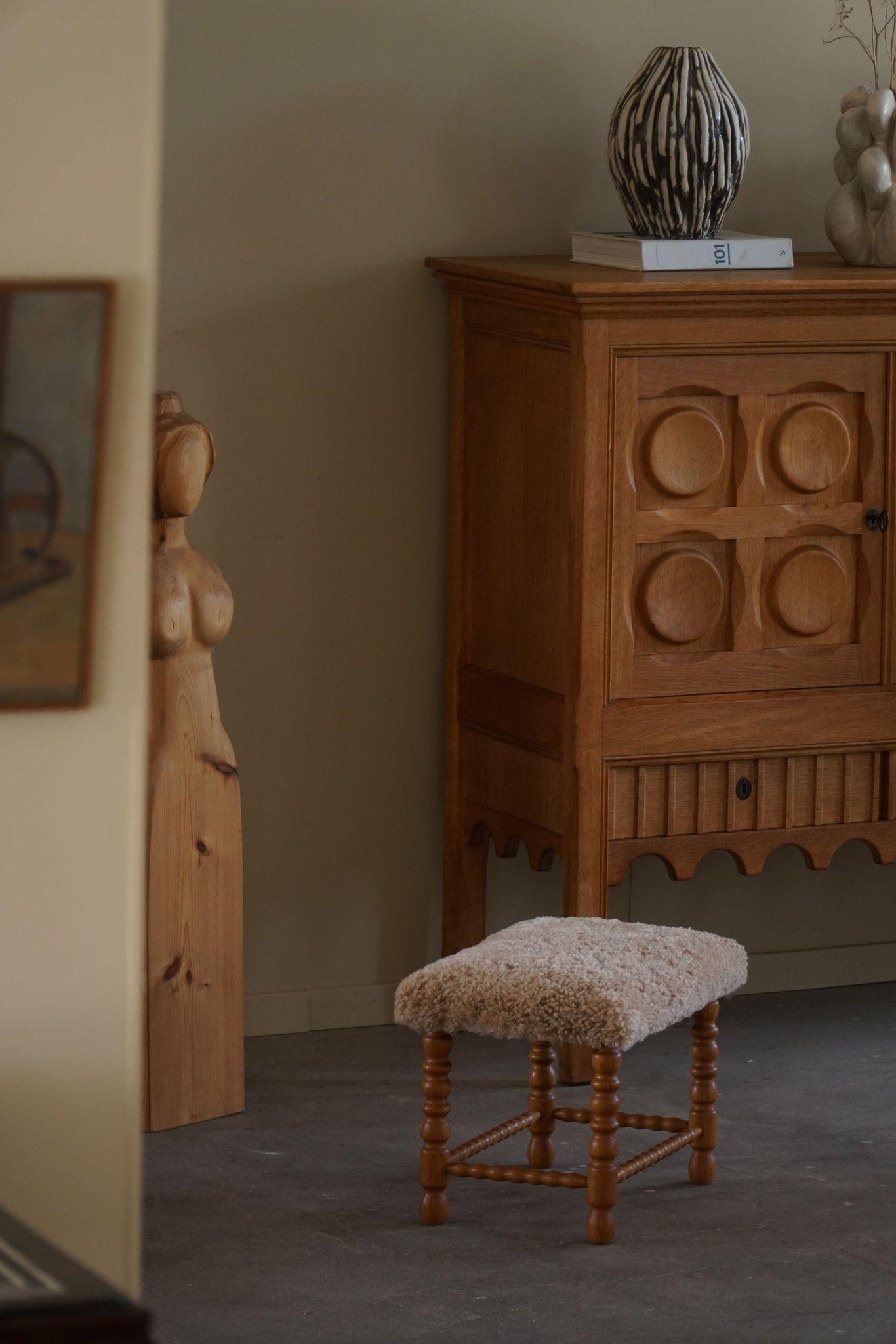 A beautiful Danish modern stool in oak with curly legs, the rectangular seat reupholstered in a great quality shearling lambswool. Made by a Danish Cabinetmaker in the 1950s. A fine stool with an intriguing impression.

A great object for the