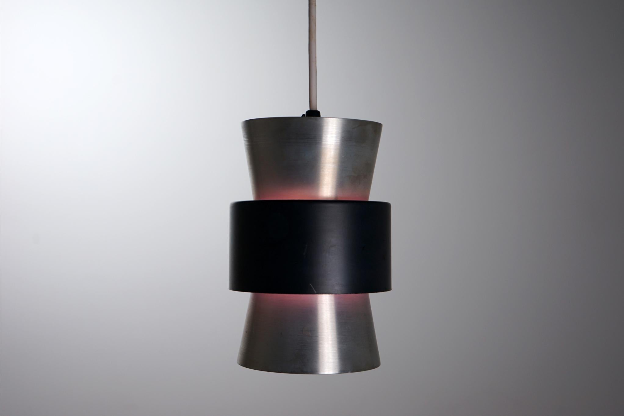 Aluminum Danish pendant light, circa 1960's. Compact design makes it the perfect addition to any corner of the home. Geometric lines with contrasting black middle band painted on inside to reflect violet when lit. In original condition, sold